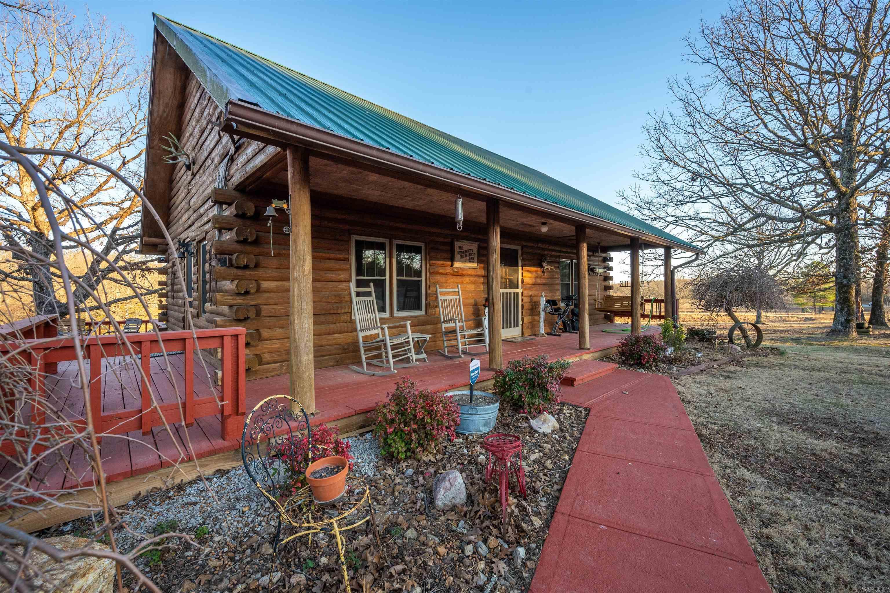 Quality Country Cabin Charm! Welcome Home! This log cabin is situated on approx 4+ acres w/Hwy 167 road frontage. This approx 1,648 sq Ft 3-Bed, 2-Bath, 2-Living Rm Areas, 1-Office/Sunroom boasts quality craftsmanship & style! Immediately upon arrival you notice the stunning wood logs, green metal roof, accented by the side deck, front porch, & detached 2 car shop. Out back you have a private deck to enjoy the field view behind the home too! Also behind the home is the lean to storage off the 2 car shop + an outbuilding + two portable carports! Going inside the home as you enter the front door you notice the open concept, kitchen, breakfast bar, & living room/dining combination (all depends on your desired layout), 2-bedrooms & 1-bath are located on the main level (upper level - you also enter into the upper level), one of the upper bedrooms is currently setup as a TV room. The kitchen is adorned w/stainless appliances, a gas oven/stove, microwave & dishwasher. Downstairs you have living room 2, sunroom/office, bedroom 3 & bathroom 2 as well as the laundry room too! The 2 car shop is heated & insulated. Not enough text to describe all this property offers! See Agent Remarks.