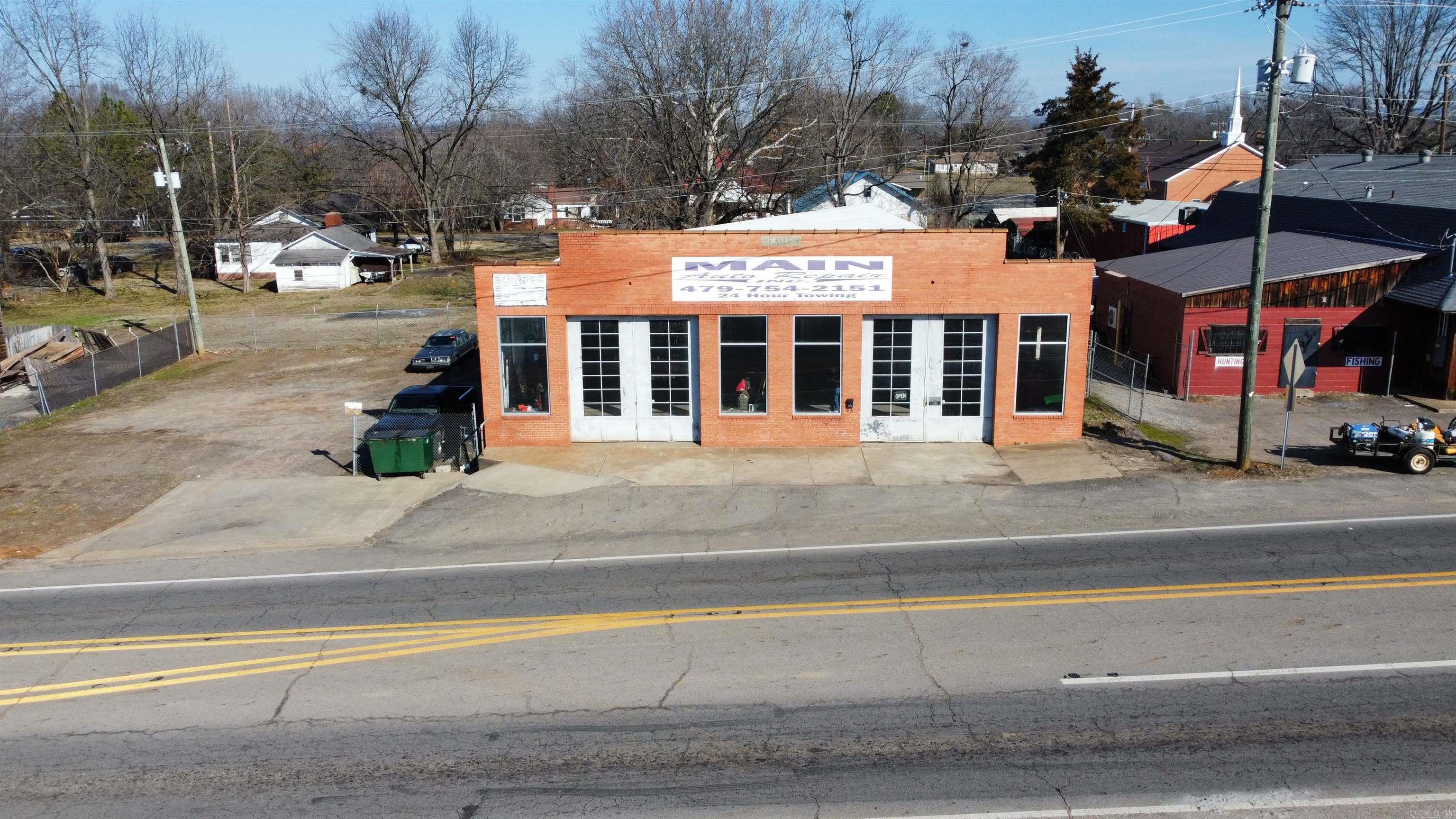 Introducing a prime commercial opportunity in downtown Clarksville, AR! This expansive multipurpose building boasts 3,696 sqft of versatile floor space, a secure fenced side, ample parking, and two sets of large sliding glass garage doors. The property includes a spacious office with a bathroom and convenient loft storage. Ideal for diverse business ventures, this property offers a dynamic space in a thriving location.