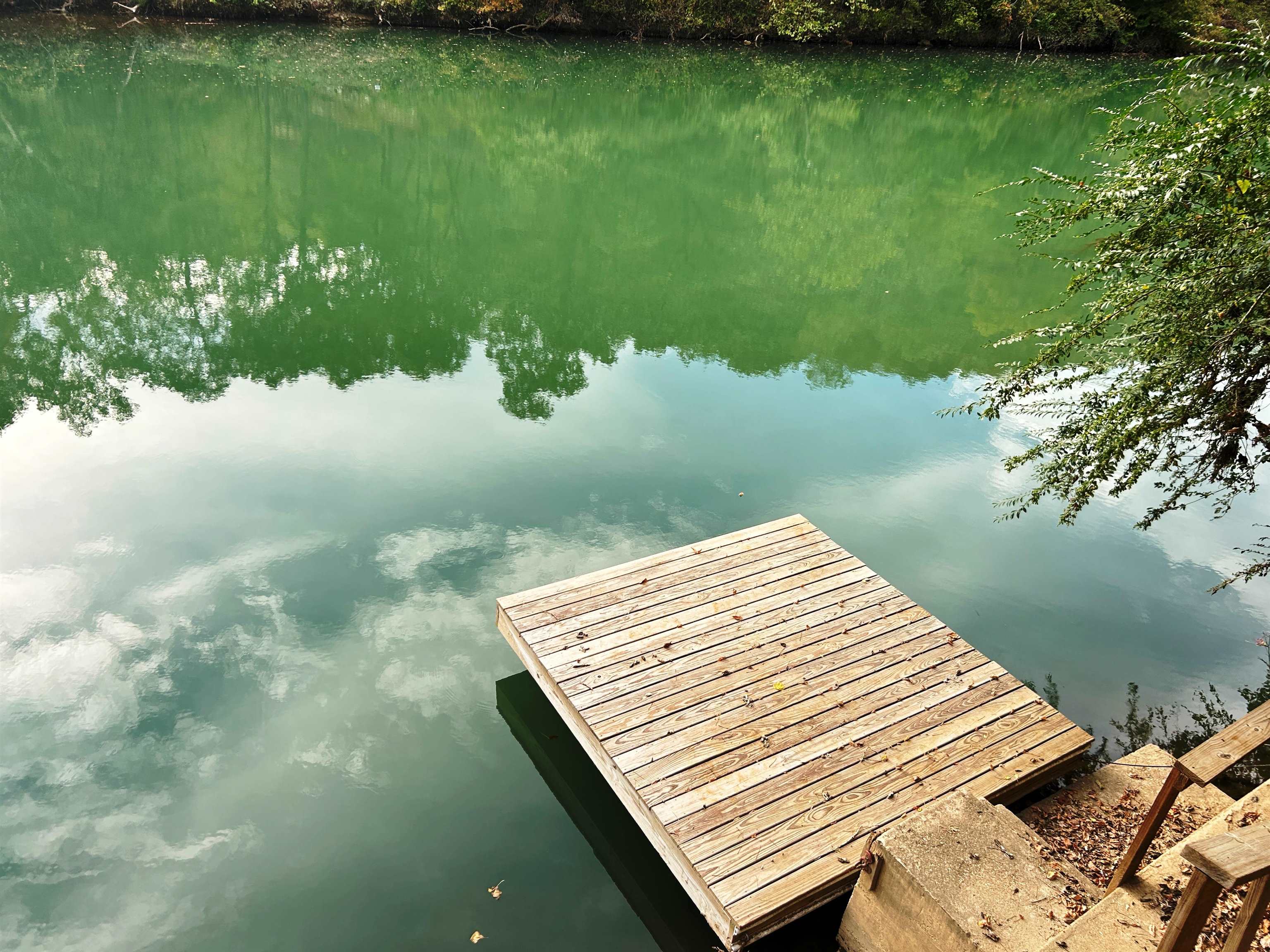 Waterfront Getaway on the Beautiful Spring River!  This riverfront lot sits on one of the best stretches of the Spring River, offering the perfect spot for relaxation and outdoor fun. The property includes a covered area with a bunkhouse, a floating dock, and a camper that conveys, giving you a great setup for weekend getaways or summer vacations.  Step out onto your private dock for fishing, swimming, or simply enjoying the view. This secure, gated community features gated access and numerous amenities, including two in-ground swimming pools, bathhouses, playground and yearly activities to enjoy, such as music and fireworks.  Annual dues ensure most of the work is done for you (even pump service) - you just come and enjoy the beautiful Spring River!  All this is just minutes from historic Hardy, Arkansas. Come enjoy the peace, beauty, and relaxation of life on the Spring River!