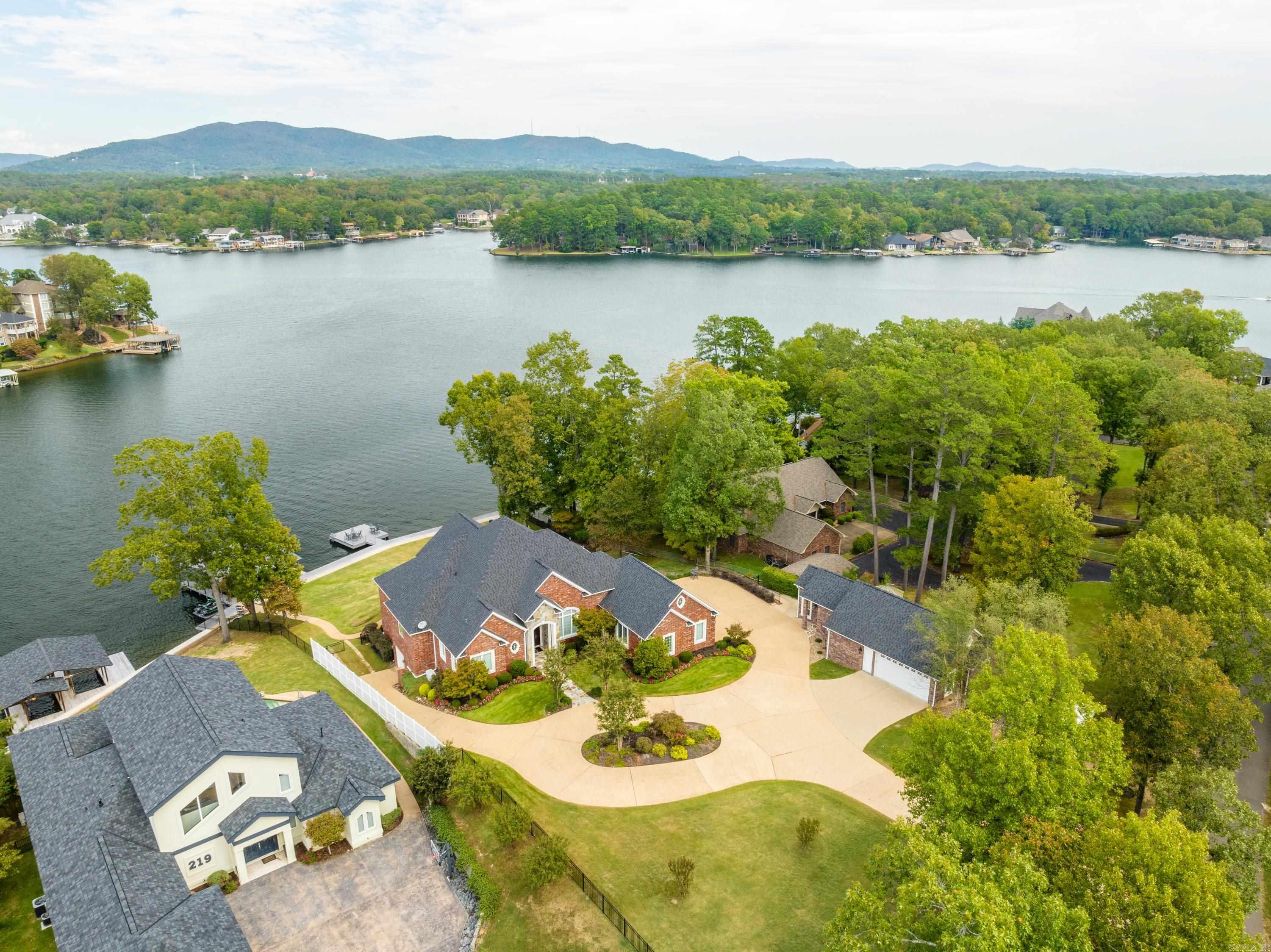 One-of-a-kind Lake Hamilton Estate with over 193' of lake frontage and 1.14 acres fully fenced and only 1.5 miles to Airport Road and 3 miles to the Bypass. Main House is 4908 Sq. Ft. with 5BR/4.5BA. The Detached Office & Movie Theatre is 602 Sq. Ft. and includes a 2 Car Garage, Half Bath, Kitchenette/Wet Bar, Pop Corn Machine, High-End Theatre and Sound System Electronics and 9 Luxurious Beautiful Red Recliners for your movie viewing pleasure. This is luxury lake living at its finest with no attention to details overlooked. Master Suite and 2nd and 3rd Bedrooms and Baths, Kitchen, Breakfast Bar, Breakfast Nook and Great Room, Formal Dining Room and Utility Room are all located on the main level. The lower level is an In-Law Quarters with a full Kitchen, Bedroom, Bathroom, Washer/Dryer, Safe Room, Workout Room/Golf Cart Garage, and a Large Office that could be used as a 6th Bedroom with a closet located across the hall.