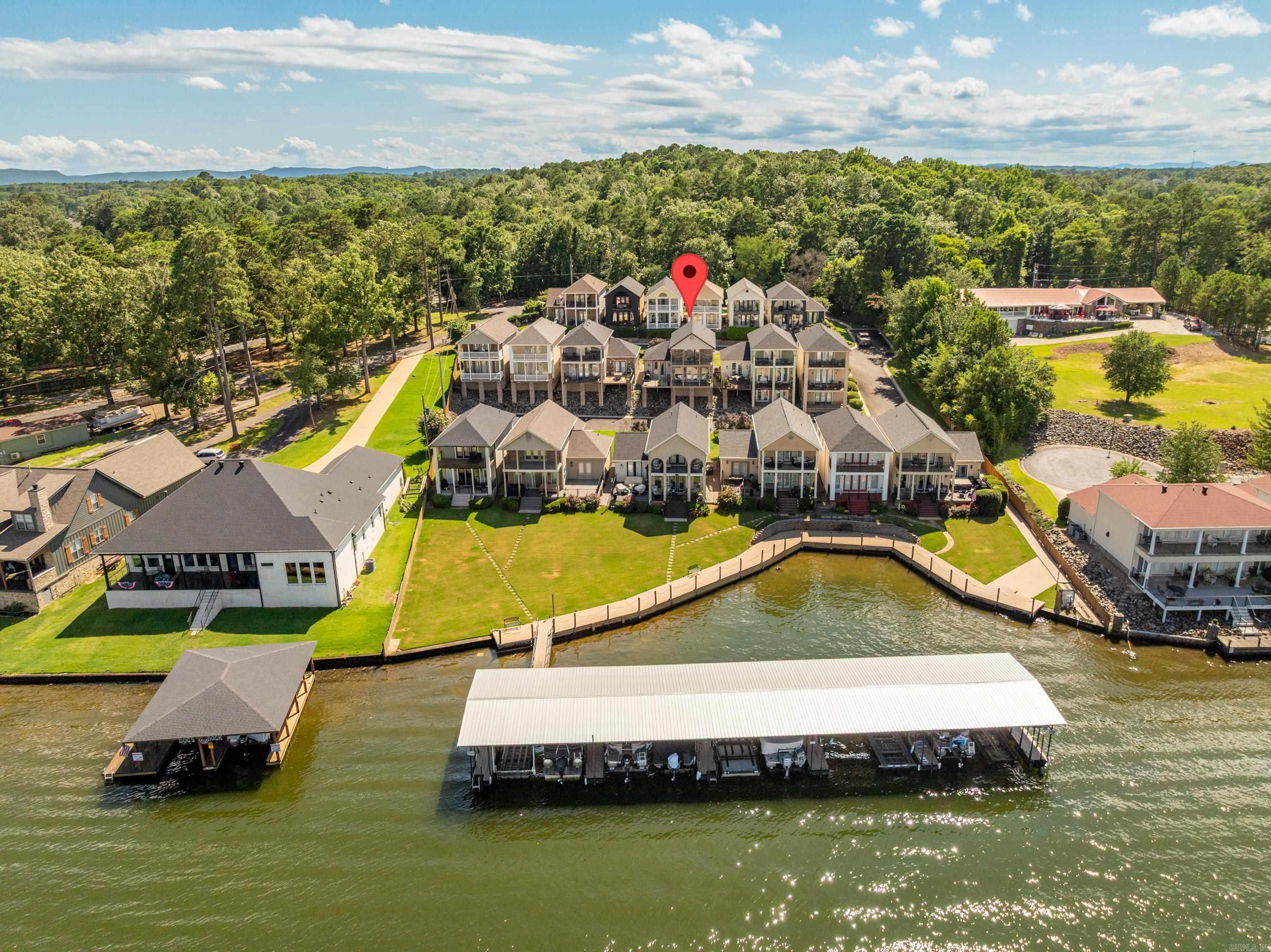 Gorgeous Lake Views and a BOAT SLIP w/ a Lift await you @ 108 Eagleview Point! Nestled on the 2nd Row, this Townhome features an Open Floor Plan on the Main Level. The Kitchen is equipped with Beautiful Cabinetry, Quartz Countertops, an Island and Dry Bar. The Living Space features Large Windows overlooking the Lake, a Gas Log Fireplace and Hardwood Floors. The Primary Bedroom is on the Main Level, as well as a Powder Bath. Upstairs is Home to 2 Additional Ensuites that your Family & Friends will LOVE! There are 2 Levels of Generous Outdoor Living Space, both Covered and Uncovered, providing Year-Round Use. Great Storage, 2 Car Garage, Nice Front Patio - this Gem offers Comfortable Lake Living! Boat Slip #9 Conveys and the Lift is 22' Long and Built to Hold a Pontoon Boat. The Location is Fabulous by Land and Water... being just Minutes by Land from the Neighborhood Market and Numerous Restaurants and a 2-5 minute Boat Ride to Bubba Brews or Sam's Pizza!