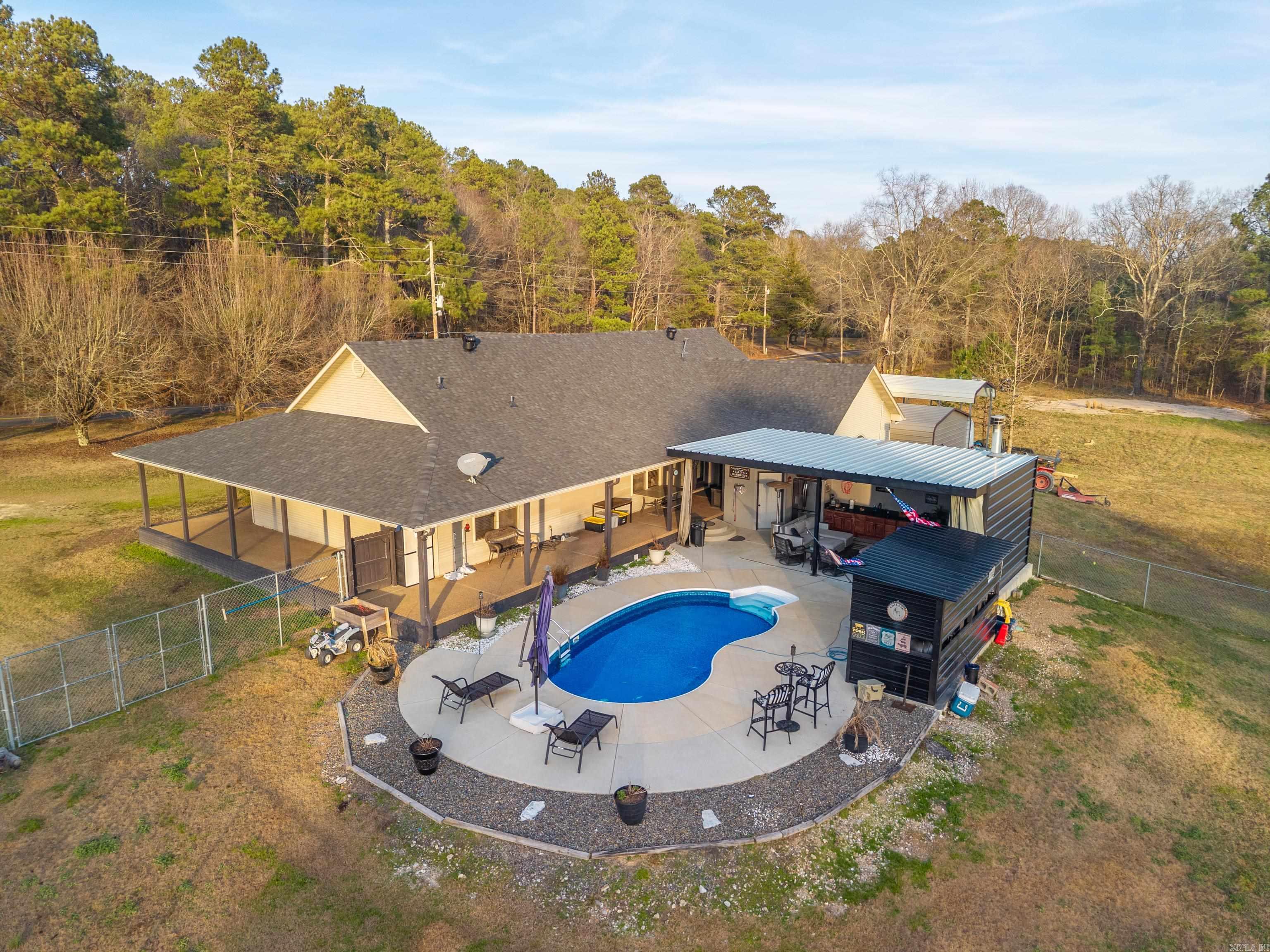 Stylish, classy, beautiful countryside living at it's best! This gorgeous home with 18' ceilings, designed concrete flooring, large rock fireplace, open floor plan on the inside, then opens up to a dreamy outdoor kitchen area with another fireplace and a tv for entertaining guest who can also enjoy the welcoming in-ground heated, saltwater pool. The  heated/cooled detached garage and is the perfect work space,  where the owner has rebuilt many beautiful classic cars or for any other workshop area you may want.  All of this sits on beautiful 2 acres where you can enjoy other outdoor activities or a place to park your boat, rv or any other toys.  The back yard is fenced in to keep your fur babies safe, yet they have plenty of room to play.