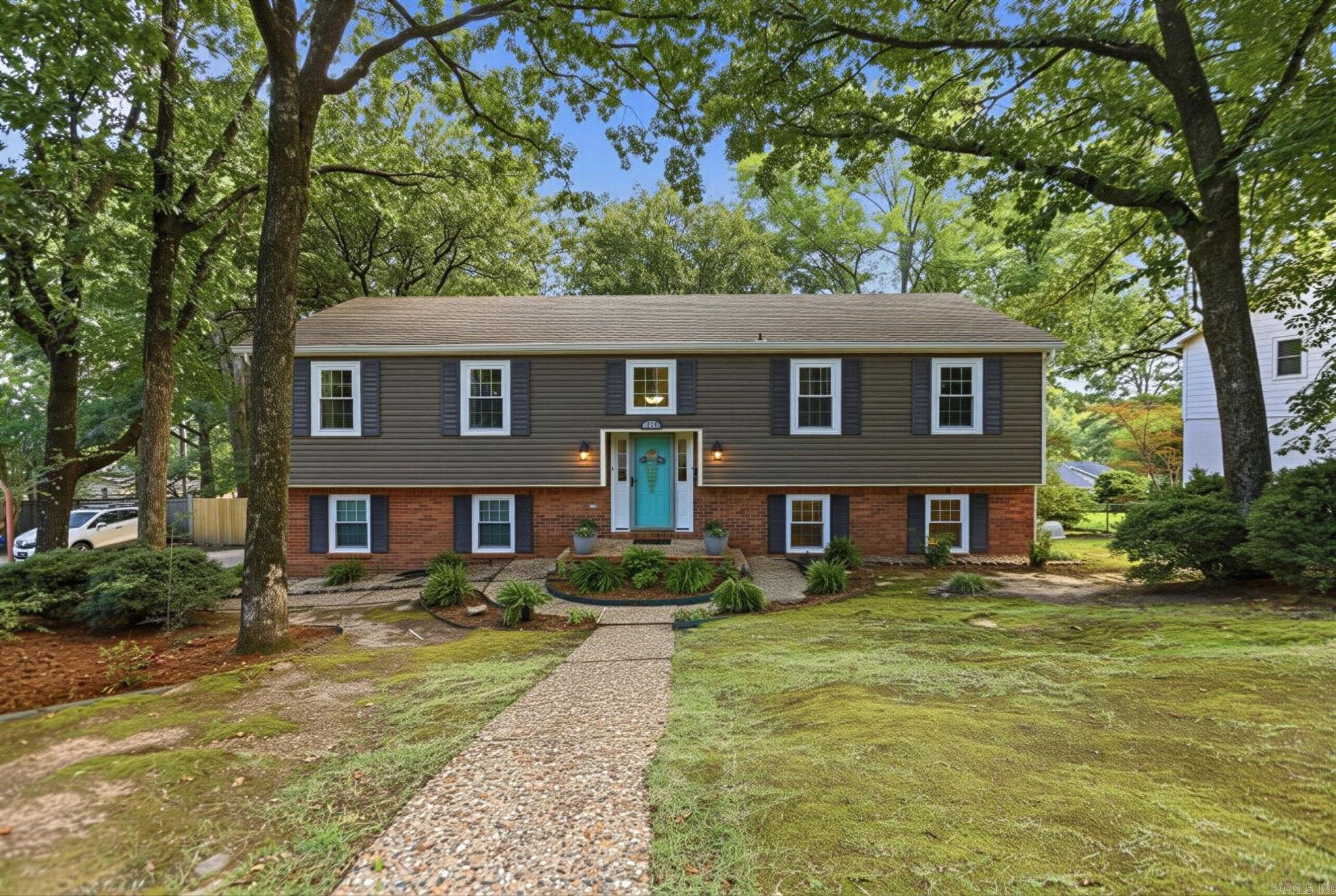 Tucked among mature trees in highly coveted Pleasant Valley, this spacious West Little Rock home offers flexible living, a beautiful backyard & room to gather inside and out. This spacious 4-bedroom, 3-bath home offers a flexible floor plan with multiple living spaces and room for everyone. The main level features a generous living/dining room, a comfortable den/family room open to the kitchen and great natural light throughout. The kitchen offers crisp white cabinetry, bar seating, stainless steel appliances and an easy flow into the family room with a gas-log fireplace. Downstairs, a large additional living area with a full bathroom with walk-in shower & soaking tub makes the perfect game/media room, guest retreat, or even a private lower-level primary bedroom retreat (AI pics). Outdoor living is a highlight with a large deck overlooking a beautiful, tree-filled fenced backyard. Walkable to the local elementary school and convenient to shopping, dining, and everything West Little Rock has to offer, this Pleasant Valley home blends space, location and lifestyle. NEWER Windows, Siding & NEW Flooring.