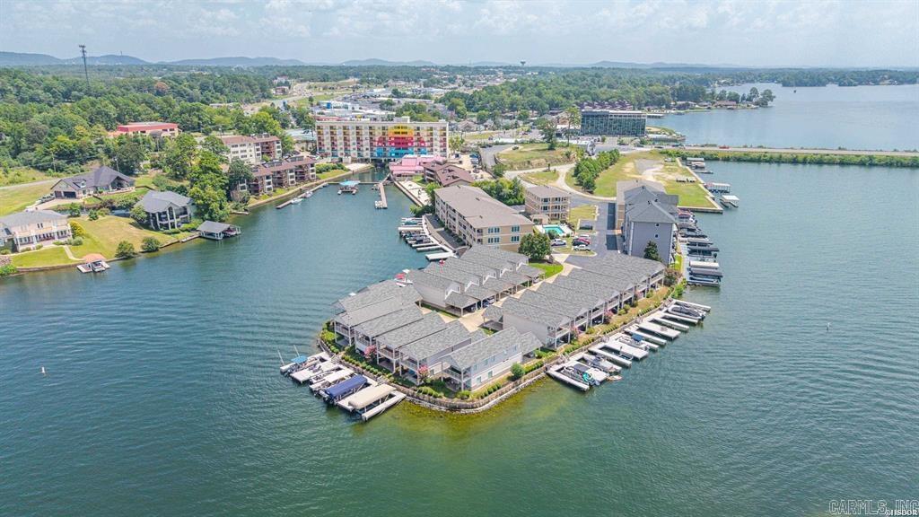 Welcome to luxury lake living in the highly sought-after 7 South corridor, where comfort, style, and breathtaking views come together in this exceptional 3-bedroom, 3-bath condominium. Located within a gated waterfront community on beautiful Lake Hamilton, this spacious 2,950-square-foot residence offers an ideal blend of elegant design and everyday functionality.  From the moment you step inside, you'll be captivated by the expansive views that can be enjoyed from two private balconies overlooking the sparkling community pool. Whether you're sipping your morning coffee as the sun rises or unwinding with family and friends in the evening, these outdoor spaces provide the perfect setting to enjoy waterfront living.  Designed with both entertaining and privacy in mind, this thoughtfully planned floor plan offers two distinct living levels. The lower level features a private bedroom with full bathroom. Along with its own separate living area and kitchenette making it an ideal guest suite, in-law quarters, home office, or media room.