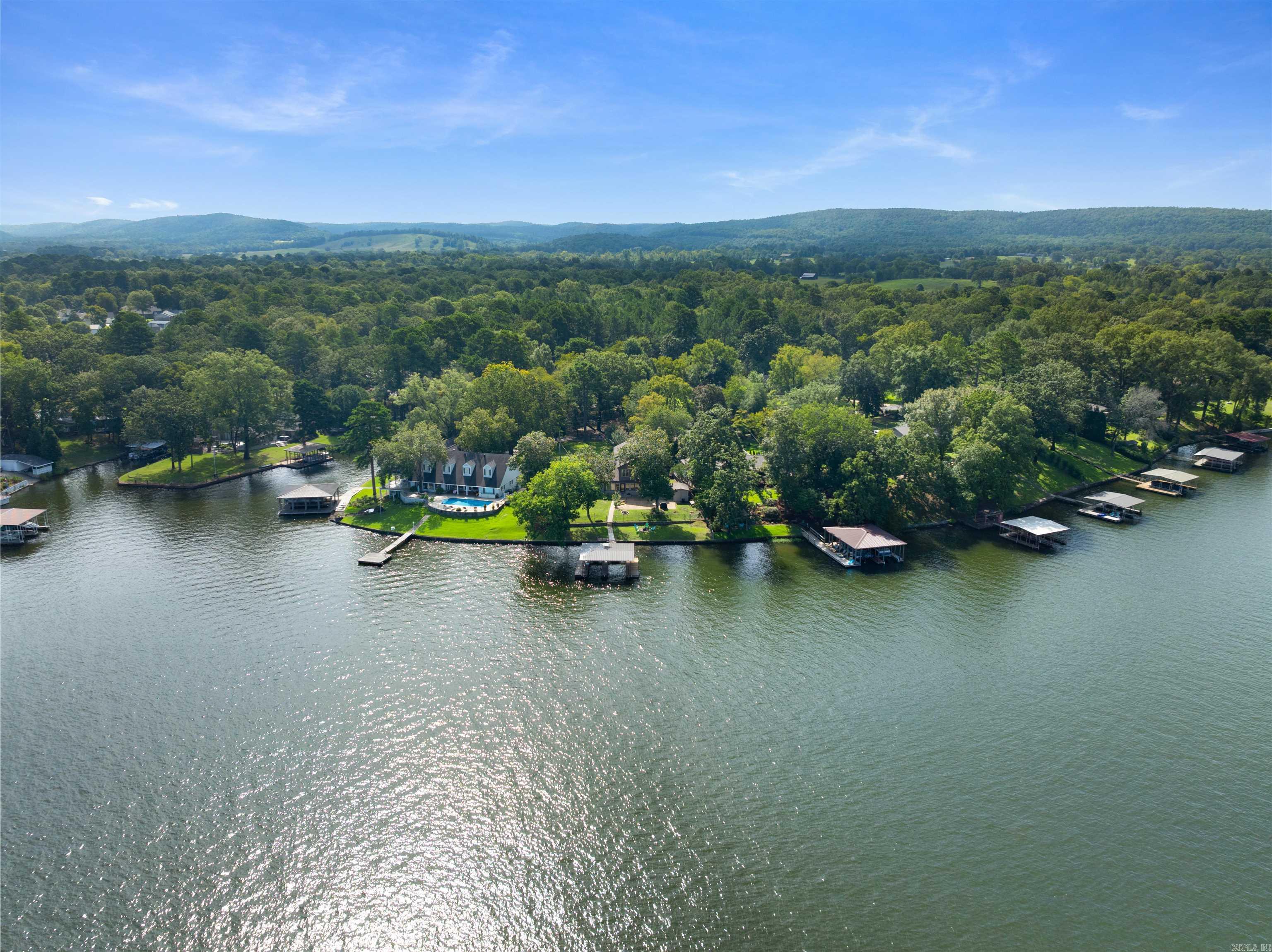 Prime Lake frontage in Hwy 7 South Area, Caroline Acres Addition and Lakeside School district. The lake lot is the main attraction with 130 degrees line of sight water view from back step. Take in sunsets behind Jack Mountain, sweeping open water views down the main channel, and in the distance to the north you can see all the way to West Mountain and the Mtn. Tower. A double boat dock in year round water is ready for watercraft, and a remodel 10 years ago brought plumbing and electrical into the 21st century. Again, the lake lot is the star here and the home is basic and simple, although a good candidate for either your re-imagining or tear down to build your dream lake home. (some empty rooms virtually staged)