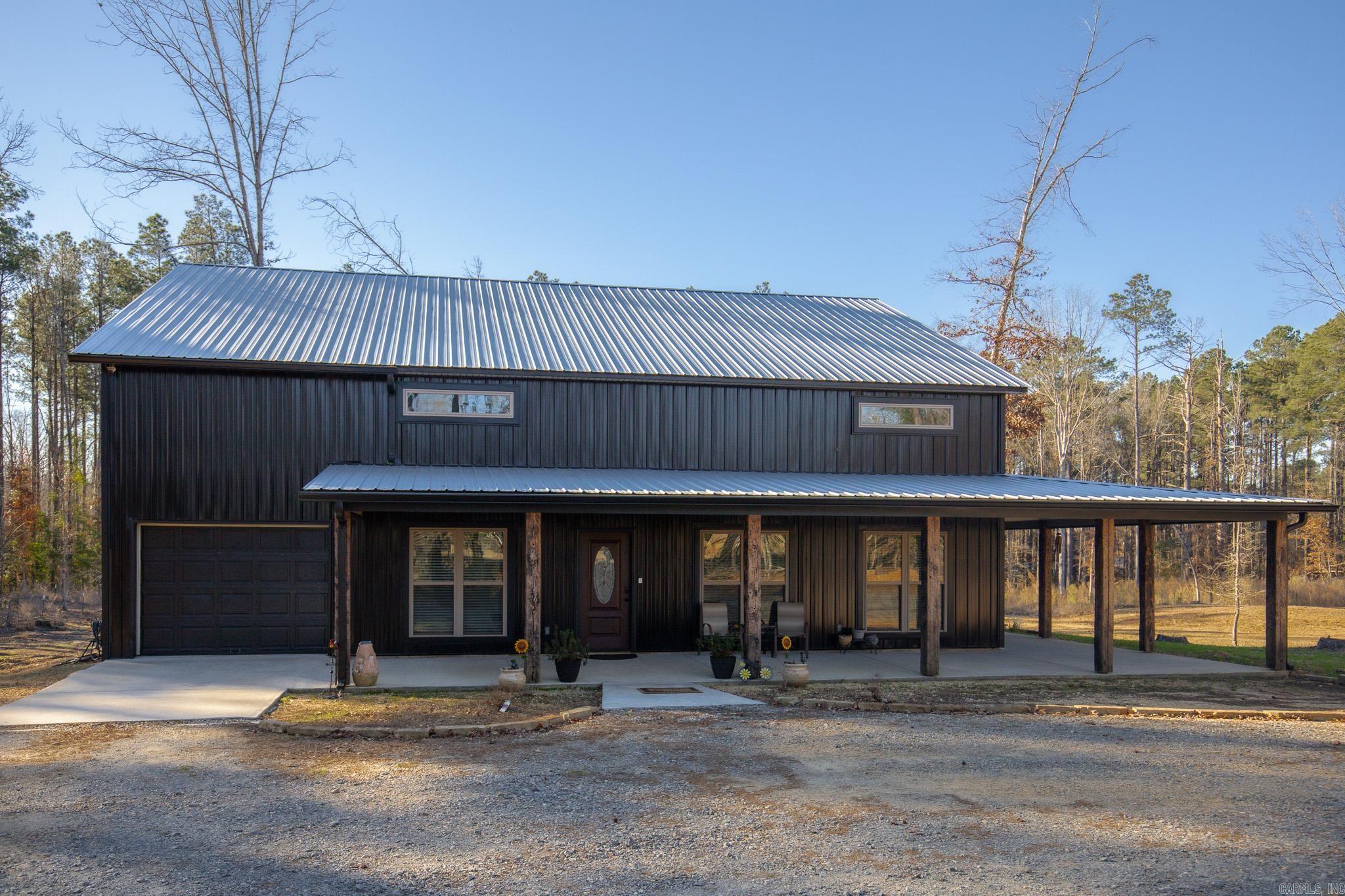 Welcome to your dream Barndo on 5.17 acres! This custom home offers 3,760 sq ft of heated and cooled living space plus garage area, all sitting on a 40x50 slab and stick built with 2x6 framing and durable metal siding. Inside you’ll find 4 bedrooms, 3 full bathrooms, and 2 bonus areas. The primary suite is downstairs along with an additional full bath for guests. office or bedroom space, walk in pantry and laundry are downstairs also. Upstairs features 2 bedrooms (walk in closet) and a bathroom with two bonus room areas (with closet) The kitchen was designed to impress with black granite countertops, farmhouse apron sink, touchless faucet, stainless vent hood, gas stove, and a large walk-in pantry with room for freezers. Enjoy cozy evenings by the natural stone gas fireplace with concrete hearth. Built for efficiency and comfort, this home includes spray foam insulation, separate controlled upstairs HVAC with built-in humidifier, gas tankless water heater, and a wired commercial-grade security system. Relax on the wraparound porch supported by beautiful Douglas fir posts and enjoy peaceful country living just minutes from town. The 1-car garage/shop space adds flexibility