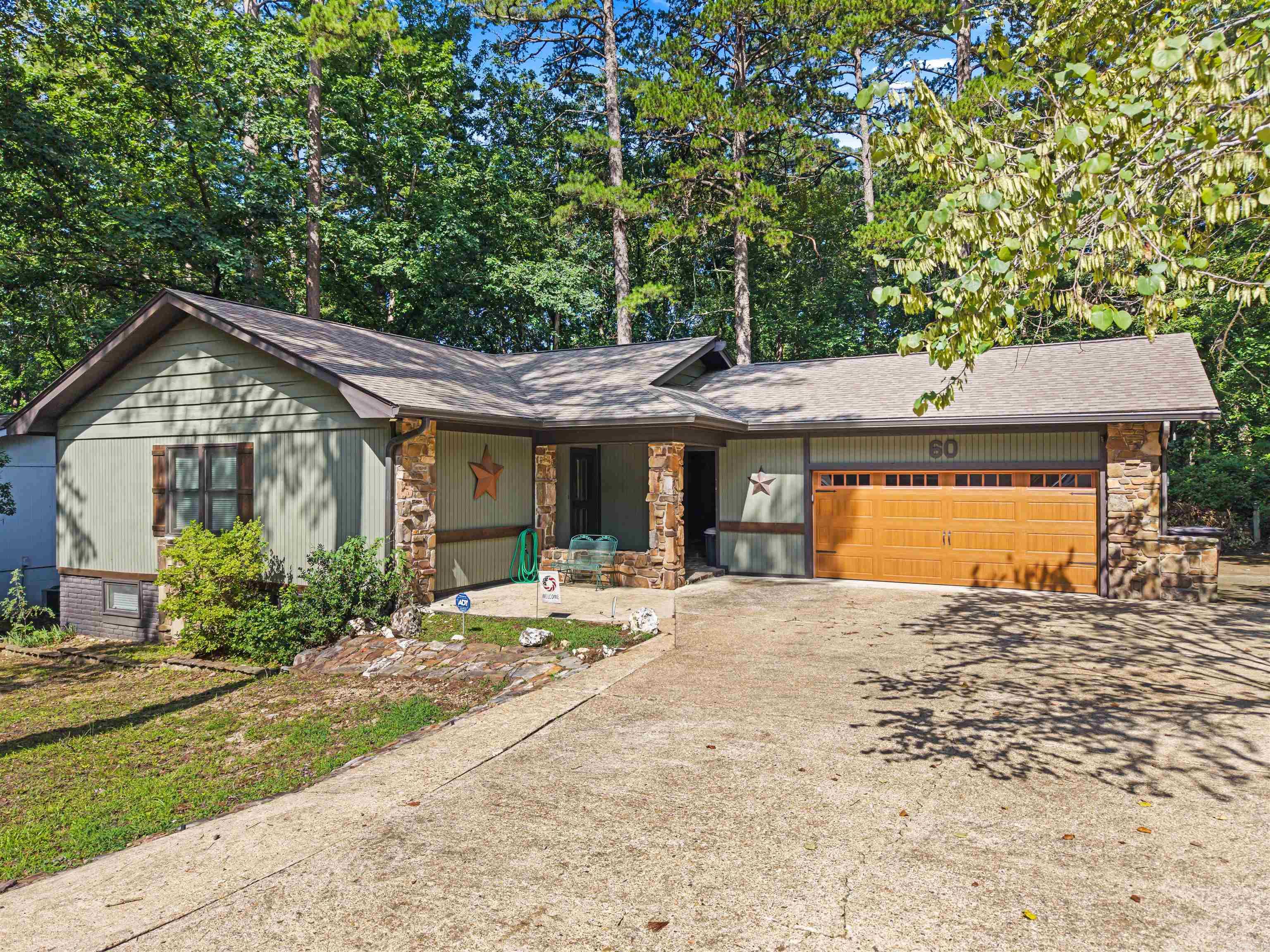 Welcome to 60 S Pego Way, nestled in one of Lake Desoto's most established and charming neighborhoods in Hot Springs Village. This spacious home features a walk-out basement, a dedicated media room, and generous living areas designed for entertaining family and friends. A detached garage is connected by a beautiful natural stone breezeway, adding both character and curb appeal. Step outside onto the expansive wood deck, where you can enjoy peaceful mornings with a cup of coffee or unwind in the evenings surrounded by the beauty of nature. Whether you're looking for room to host guests or simply relax in a quiet, established setting, this home offers the perfect blend of comfort, charm, and functionality. Ideally located just minutes from Lake Desoto, scenic walking trails, and the golf course, you'll enjoy easy access to some of Hot Springs Village's most popular outdoor amenities. A one-time Hot Springs Village POA New Member Buy-In Fee of $2,000 applies. Square footage shown reflects the total heated and cooled living area.