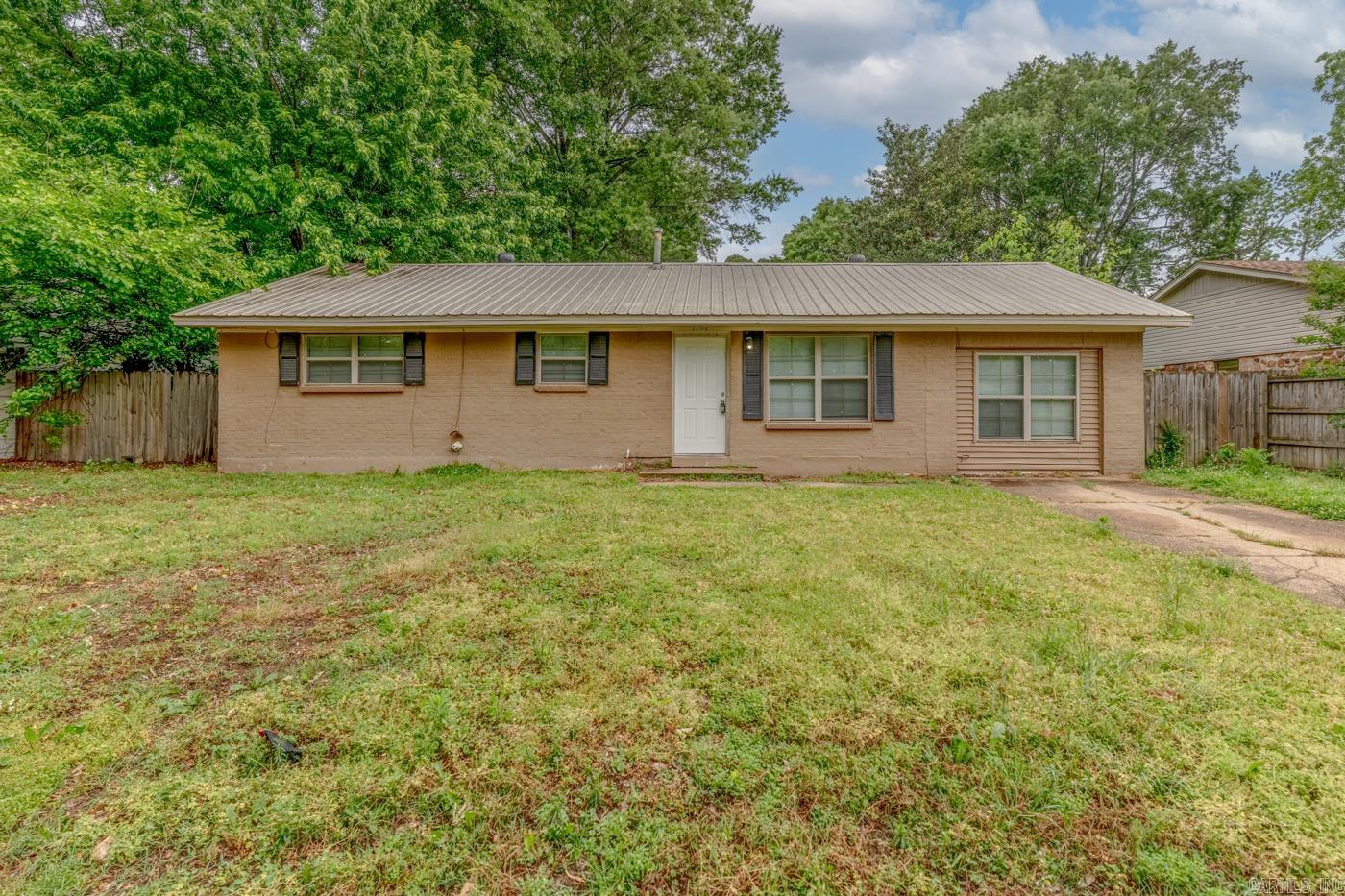 Welcome to Market 1704 Rosemond Avenue in Jonesboro, Arkansas within the Jonesboro School District. Situated on a 0.21 +/- acre level lot in the Brookhaven 3rd Addition is a ranch style home offering 1,352 sf of well laid out living space. The exterior is wrapped in brick, topped with a metal roof, and accented by shutters, mature shade trees, backyard patio, fenced backyard, and parking pad. The layout includes: living room and den, eat-in kitchen featuring abundant cabinetry, laminate countertops, electric range, dishwasher, and vent hood, Master bedroom w/ half bath, 2 spare bedrooms, and a full bathroom featuring an updated vanity and tiled shower/tub combo. You'll love the oversized laundry/storage room with additional shelving and workspace potential, neutral paint tones, and tile flooring throughout for easy maintenance. Conveniently located near favorite local amenities. Call today to schedule your tour and make this house your home or next addition to your rental portfolio.