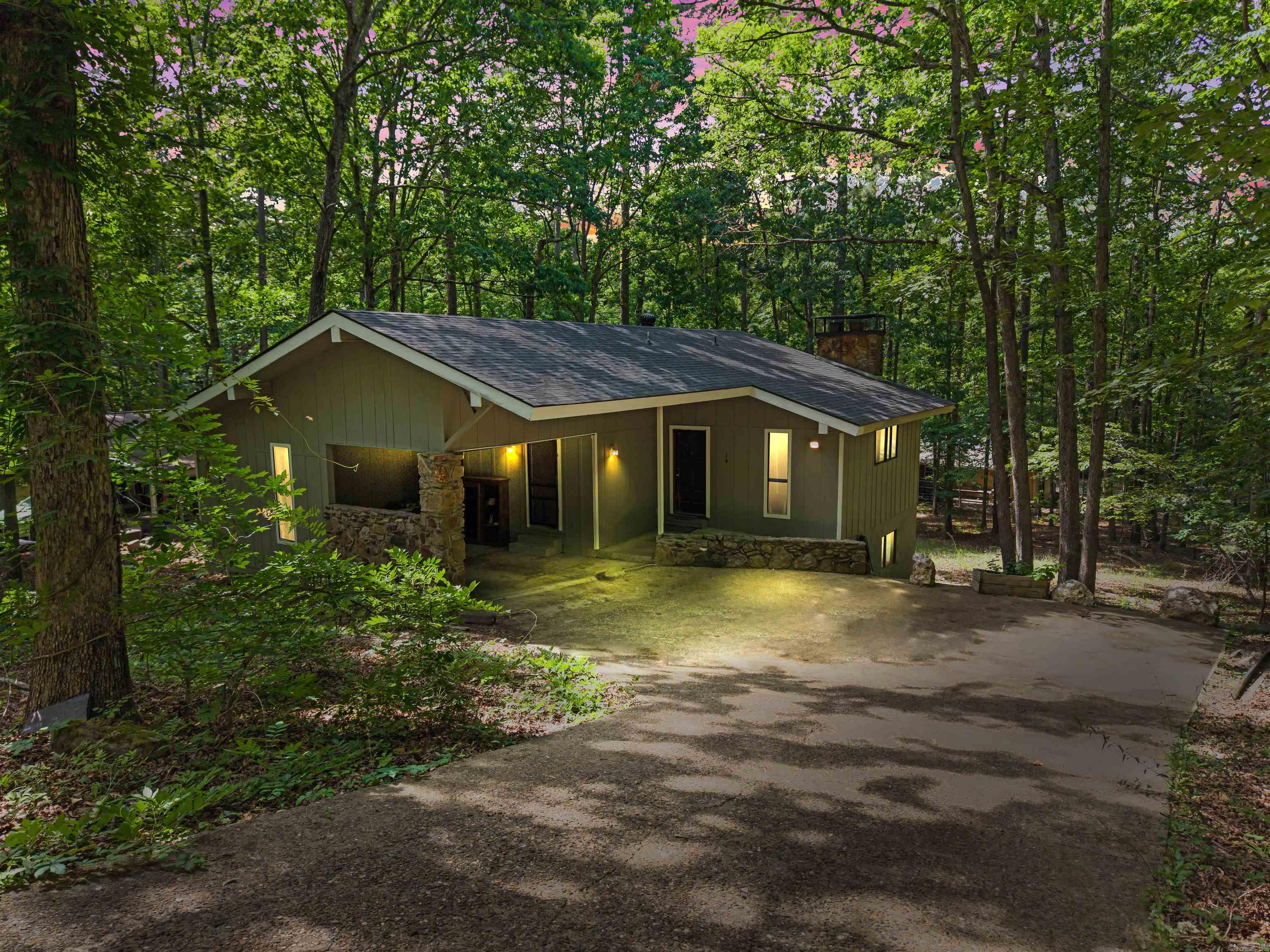 Come check out this charming 3-bedroom, 2-bath home with approximately 1,510 sq. ft nestled in the woods of Hot Springs Village. This home features a vaulted ceiling in the living room, a galley kitchen with new cabinets, and a spacious utility room with plenty of storage space. Enjoy the warmth and character of wood-burning fireplaces both upstairs and downstairs. Step out onto the back deck off the kitchen and relax while taking in the beautiful mature forest setting. The large workshop area under the home offers great space for hobbies, projects, or additional storage. Recent updates include a new roof in 2024, new interior and exterior paint, and new flooring. Agents see remarks.