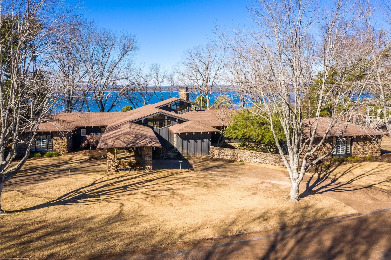 Eden Isle Masterpiece with a view!  A BIG VIEW!  This 4/5 bedroom home overlooking Greers Ferry Lake to the west has one of the best sunset views on the island!  Rustic contemporary architecture that would make Frank Lloyd Wright proud!  Enormous greatroom for entertaining, massive stone fireplace, walls of glass, all rooms in the house (w/ exception of 1 bedroom) view the lake!  1-car portico plus 2-car garage.  Exceptional!