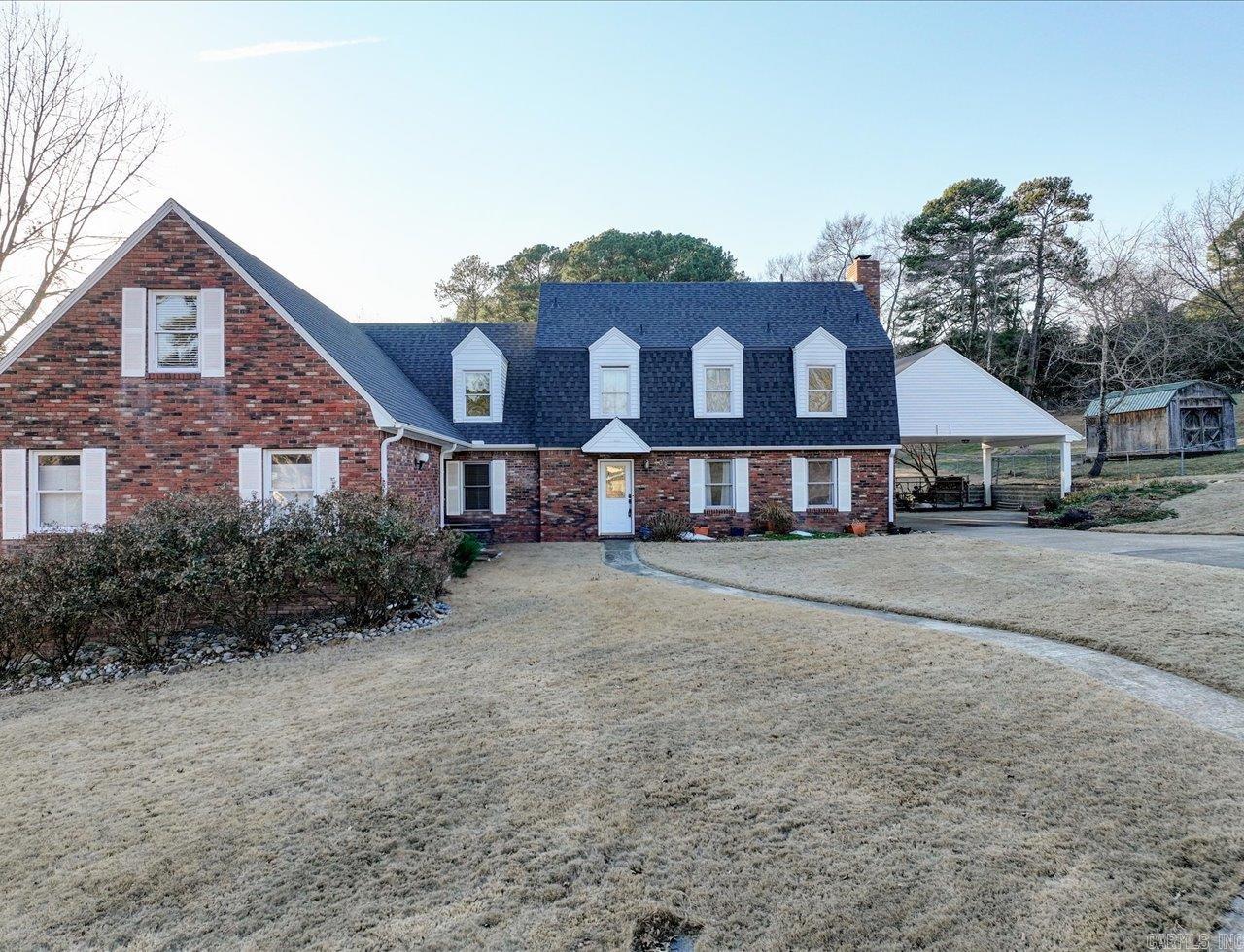 Custom-built, one-owner 5-bedroom, 5-bath home on a corner lot of nearly 1.3 acres. Grand entry with high ceilings and staircase. Den features built-in shelving and gas fireplace. Spacious primary suite with walk-in closet and en-suite bath. All bedrooms and full laundry room located upstairs, plus additional washer/dryer hookup downstairs.  Kitchen-adjacent workshop with built-in shelving. On-demand water heater. Expansive backyard with two peach trees, apple tree, and blackberry bush.  Detached approximately 1,600 sq ft studio includes a three-quarter bath, loft, and multiple rooms—ideal for studio, workspace, or flexible use (buyer to verify permitted uses). RV-height carport.  Versatile property with space to live, work, and create. Great central location to Oaklawn and the National Park