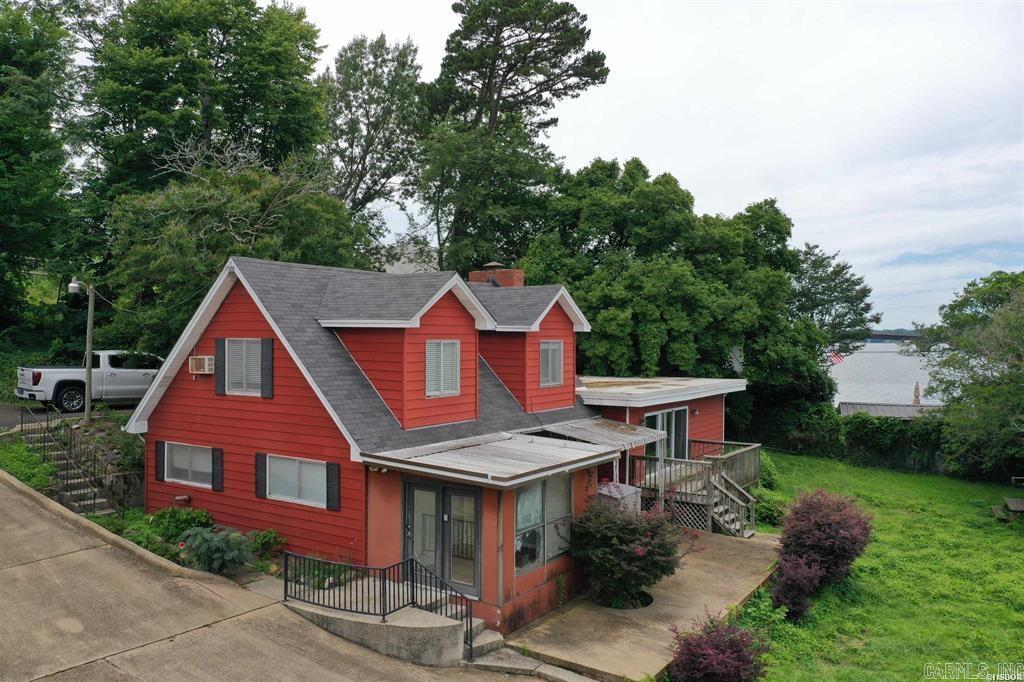 The property features a 3-bedroom, 2.5-bath lake cottage that offers endless possibilities. While the existing home has served as a charming lake retreat, it is an older cottage that will require updates and repairs. For many buyers, the true value lies in the exceptional lot and location, making this an ideal site for renovation, expansion, or the construction of a custom lakefront dream home.  Enjoy expansive water views, excellent lake access, and outstanding outdoor amenities, including a two-stall boat dock and a concrete pier extending to the dock. Whether you're looking for a weekend getaway, investment opportunity, or a future luxury lakefront residence, this property provides a rare chance to secure one of Lake Hamilton's most sought-after addresses. Value primarily in the land and location!! YES it can be a STR! Properties with this combination of views, waterfront access, and premier location are increasingly difficult to find. Bring your vision and create something truly special on Lake Hamilton.