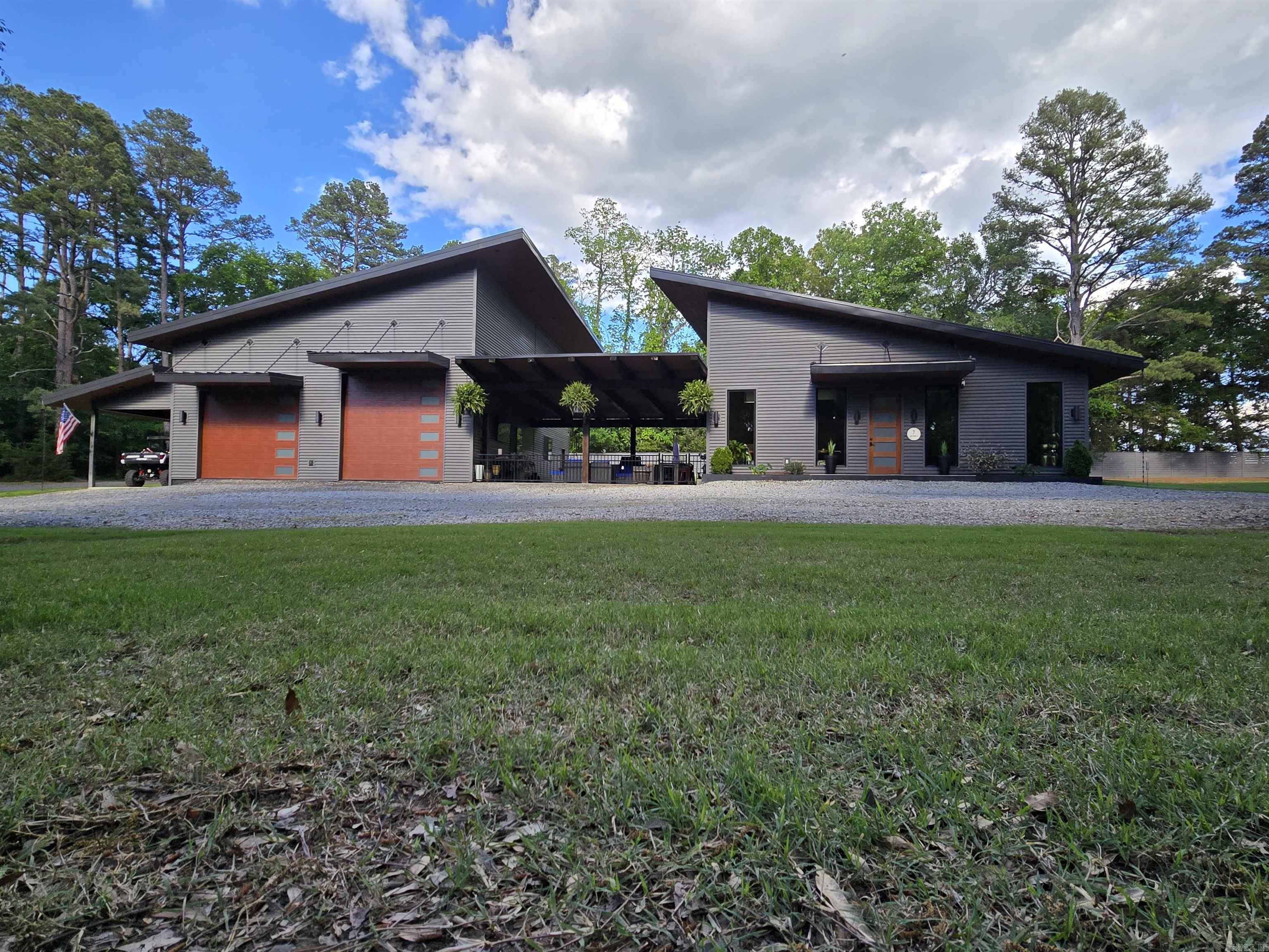 Private Luxury Estate Minutes from Eden Isle & Greers Ferry Lake. This extraordinary custom estate rests gracefully on 4.02 private acres, with potential to subdivide into three premier homesites. Offering approx. 3,850 sq ft. of refined interior living plus 1,600 sq ft. of covered outdoor living, this residence was masterfully designed for elevated comfort and effortless entertaining. The outdoor lounge features a built-in bar/seats 8, with Napoleon grill, dolomite countertops, and a 250k BTU built-in fire pit. Inside, globally sourced Italian, Spanish, and Turkish porcelain finishes, heated floors throughout, soaring 10-foot ceilings, quartz surfaces, stainless appliances, and a dramatic floor-to-ceiling porcelain fireplace wall create a sophisticated yet inviting atmosphere. The primary suite delivers a five-star retreat experience with a spa-inspired bath. A thoughtfully designed expansion wing offers flexibility for additional suites, guest quarters, or executive-level storage w/50-amp service for RV or yacht, complete with kitchen area, full bath, laundry, and a concrete safe room. Maintenance free exterior/metal roof. A rare blend of privacy, design, and lake-area luxury.