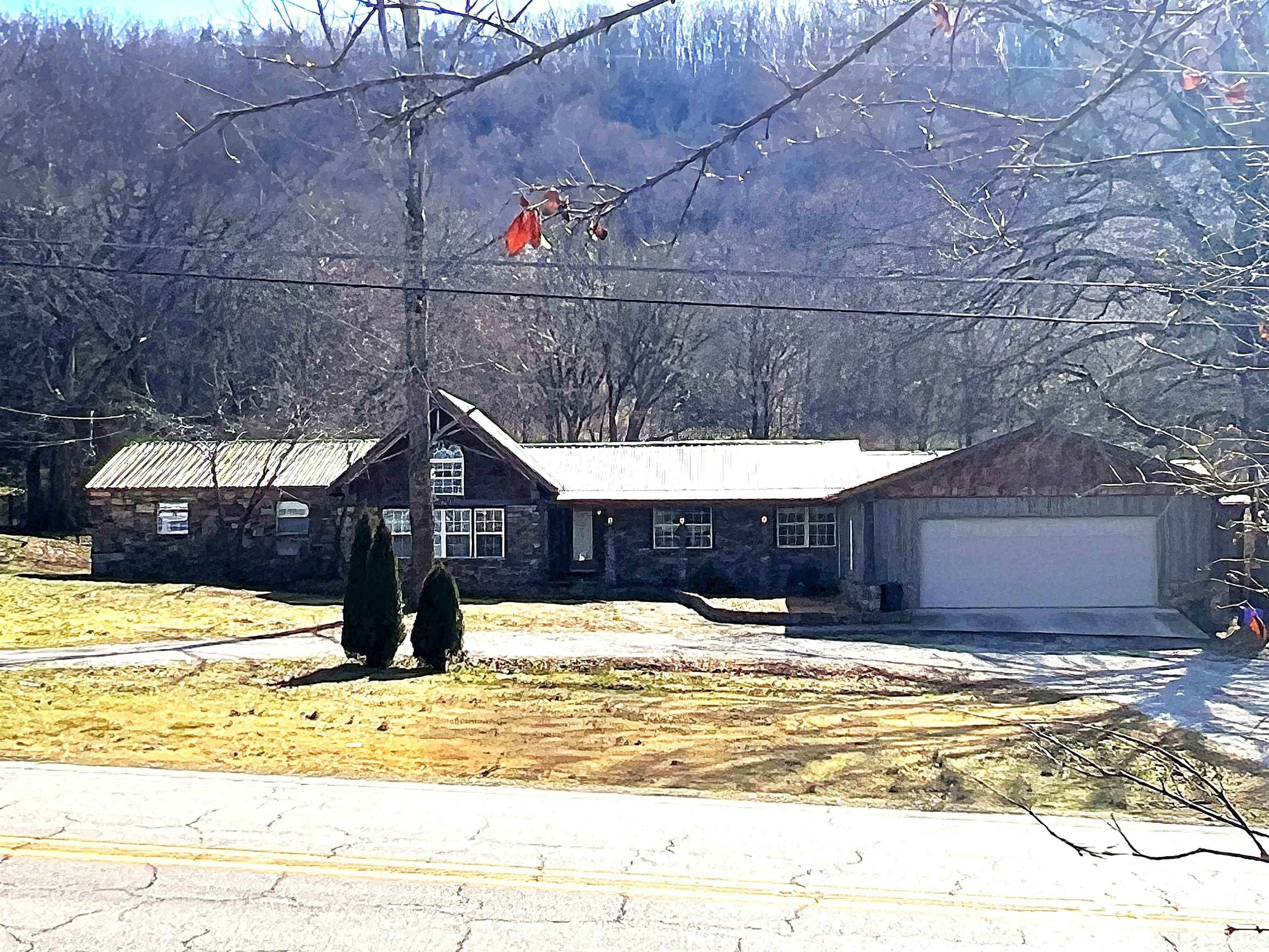 Spacious living meets Ozark scenery just outside Mountain View in desirable Stone County!  This 4 bedroom, 3 bath stone home sits on approximately 1 acre with beautiful mountain views and room to breathe. The inviting exterior and metal roof set the tone for a comfortable, well-built home designed for everyday living and gatherings alike. Inside you’ll find generous living areas and a flexible layout suited for family, guests, or multi-generational living. The cozy kitchen easily flows to the dining and main living space featuring a grand floor-to-ceiling stone fireplace and cathedral ceiling as the centerpiece of the home. The private primary suite offers a true retreat with a custom shower and an in-room jacuzzi tub for relaxing at the end of the day. A 30x30 metal building with electric adds excellent versatility — ideal for a workshop, equipment storage, or hobby space. Central heat and air, attached garage, and easy highway access make daily life convenient while still enjoying the peaceful feel of the countryside. Located just minutes from Mountain View’s shops, music, and river recreation, this property offers the balance of privacy and accessibility buyers are looking for.