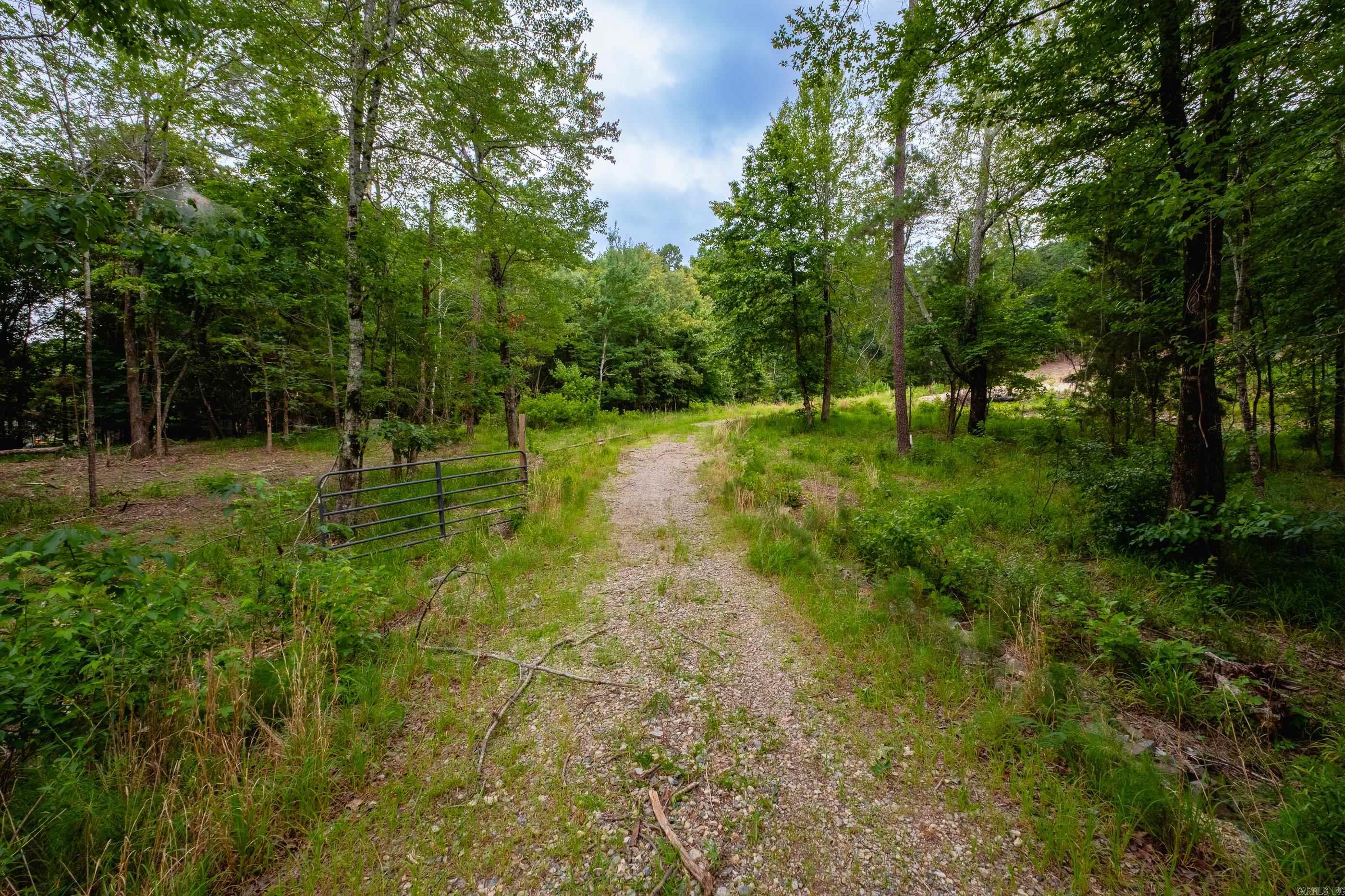 DON'T WAIT... to purchase 10 beautiful acres located off Garrison Road in West Little Rock. This property features stunning mountain views and includes an existing level building site, providing the perfect foundation for a custom dream home, a barndominium, or both. Situated off peaceful Tram Road, the location offers a serene country atmosphere while remaining conveniently located just minutes away from local shopping, dining, and city amenities. Come see it today!!