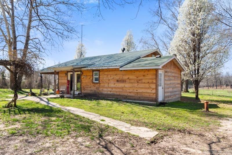 Minutes from Norfork, this 2-bedroom, 1-bath home features a mostly finished interior, with a large kitchen, cozy wood-burning fireplace, and spacious living room. Step outside to 5 cleared, usable acres that are partially fenced, with a pond, perfect for hobby farming, animals, or simply enjoying peace and privacy. The property features an expansive shop building with a kitchen, wood-burning fireplace, bar, and bathroom, ideal for a workshop, guest quarters, or extra living space. Additional structures include a separate carport, plus a large canopy with electricity and an attached building for storage or projects. Enjoy fantastic country views from the back deck, solar panels to save on electric bills, and high-speed Next Fiber internet through NAEC.