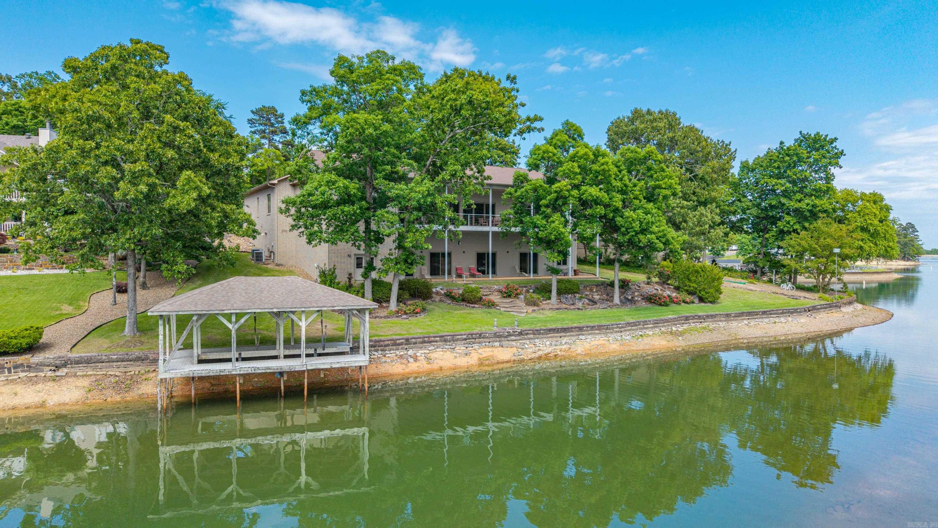 When entering the architecturally significant home, you are immediately bathed in light. This rare custom home is timeless in its modernity.  EVERY ROOM HAS THE SAME LAKE VIEW!  You will struggle to find another home on Balboa that provides the full lake view from every room, a testamentto the brilliant architect.    The soaring ceilings are on both levels and the airy modern atmosphere is just waiting for your personal touches.    Step outside and enjoy the serene setting from the large deck and lower patio or head down to the dock for a day on the water.  This home offers the perfect blend of comfort, relaxation, and recreation with peaceful waterfront views and your own private dock for fishing, boating, or simply enjoying the outdoors on Lake Balboa. Ownership in Hot Springs Village includes access to outstanding amenities such as multiple championship golf courses, lakes, marinas, swimming pools, tennis and pickleball courts, walking trails, fitness centers, restaurants, and gated security. Conveniently located near Hot Springs shopping, dining, and entertainment, this property offers the perfect combination of peaceful lakefront living and resort-style amenities.