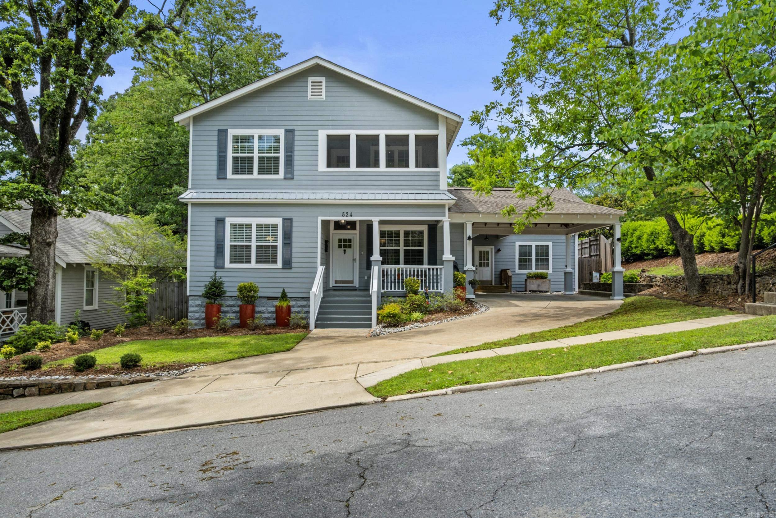 Timeless character meets elevated modern living in this exceptional, fully renovated Craftsman. From the striking blue-gray exterior and inviting front porch with wood-plank ceiling to the covered carport every detail adds to the impeccable curb appeal. Originally renovated in 2018 with an expansive addition completed in 2021 that offers a luxurious primary suite, dedicated office, mudroom/laundry. Two primary suites provide flexibility for guests or multigenerational living.  Inside, hand finished hardwood floors lead through light filled living spaces anchored by a beautiful fireplace, a showstopping chef's kitchen featuring custom cabinetry with a professional DCS range, oversized island, wine cooler and double ovens. A separate library with built-in bookshelves and window seat adds cozy charm. Upstairs, heart pine floors extend throughout three spacious bedrooms, including a serene spa inspired primary ensuite. The outdoor living seals the deal: two covered back porches with tongue and groove pine ceilings overlooking a private backyard with handcrafted treehouse. The walkability of this house to local schools and restaurants in Hillcrest add to the charm. AGENTS SEE REMARKS!!