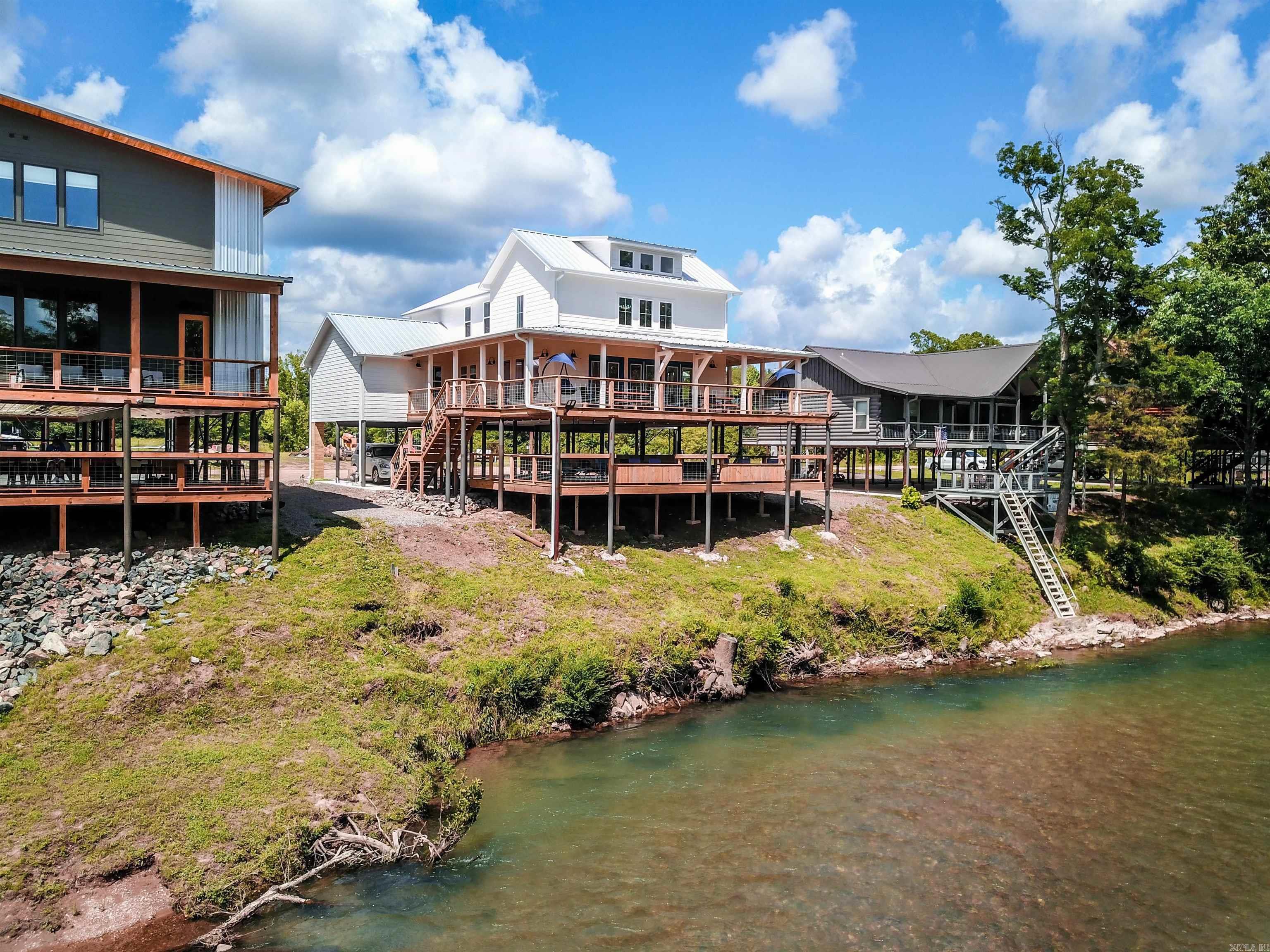 HAVE IT ALL WITH A TWO YEAR PROVEN TRACK RECORD OF RENTAL HISTORY AND INCOME!  “The Whitewater" is a new construction cabin perched on the banks of the Caddo River! This 3000 sq ft cabin is 5 BR, 5.5 Bath, located in a private gated community W/ camera surveillance, excellent WIFI/Fiber Internet, & comes fully furnished! The cabin can sleep up to 19 people, has 1500 sq ft of wraparound decks that boasts beautiful views of the Caddo River, parking underneath, & more! Property has an approximate yearly revenue of $95,000 - $100,000! Perfect business venture! Property is currently booked through VRBO, and has room to grow! Property also has service contracts in place for cleaning, A/C, pest control, and lawn care. All the hard work has been done for you with this popular vacation rental! Such a unique opportunity to own right to the center of the sought after Caddo River! Rent at your leisure to cover expenses & enjoy!