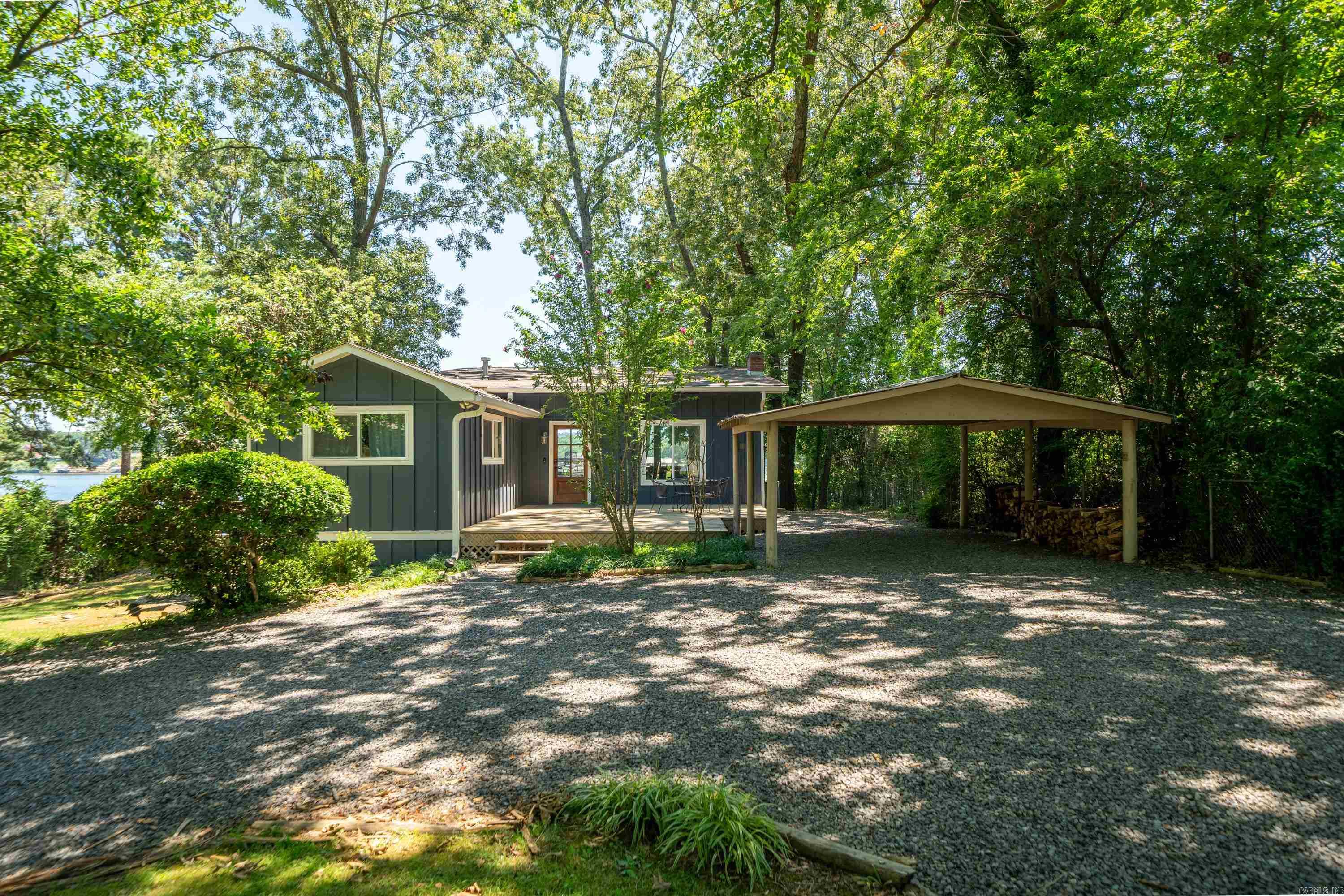 Discover one of the most unique and desirable luxury nightly rental retreats on Lake Hamilton. Situated on a beautifully manicured 1-acrelakefront parcel just off the main channel, this exceptional property features three separate dwellings that sleep a total of 16+ guests ,making it ideal for short-term rental income, a private family compound, or both. Offered fully furnished and turnkey, this retreat has a proven track record as a highly successful vacation rental and is located outside Hot Springs city limits—meaning no special license is required to continue using it as a short-term rental. The main house offers 1,628 square feet of beautifully updated living space, designed o take full advantage of the lake views with a dramatic wall of windows across the open-concept living, dining, and kitchen area. The kitchen features quartz countertops, a large island for entertaining, and stainless steel appliances. The main level includes the primary bedroom and a full bath, while the lower level offers a second living space, a bunk room, an additional bedroom, and a full bathroom with washer and dryer.