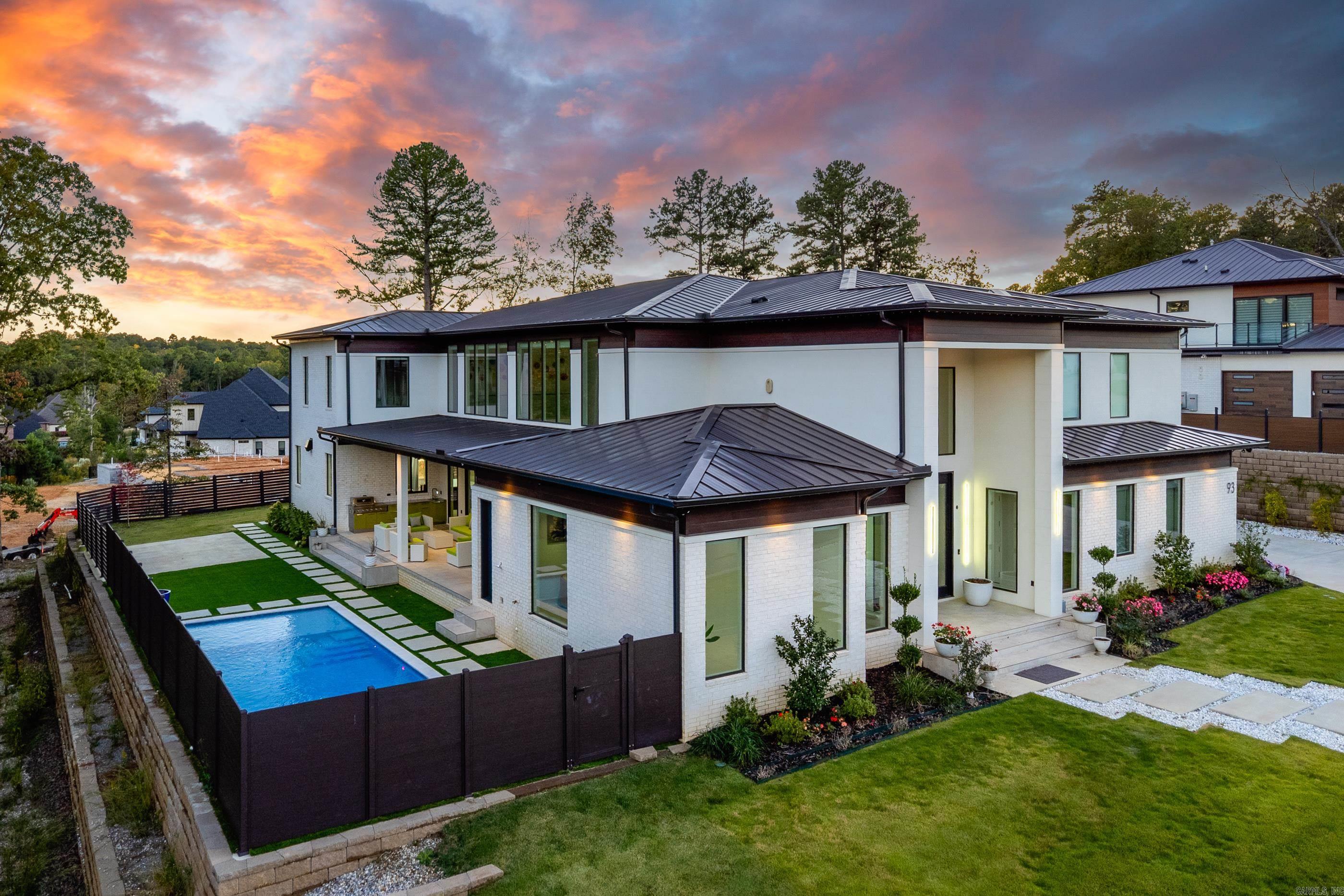 Completely custom-built, one-owner modern luxury home located in Chenal Valley’s prestigious gated Orle neighborhood in West Little Rock. This exceptional residence showcases high-end finishes and cutting-edge design throughout, featuring acrylic doors, frames, and cabinetry, a grand entryway, private office, and dedicated work area. The gourmet kitchen boasts dual islands, a separate prep kitchen, and seamless integration with the living spaces. Additional highlights include an impressive media room, bonus room, and all bedrooms with en-suite baths. Outdoor living is equally stunning with a resort-style pool surrounded by turf, covered patio with outdoor kitchen, pool half bath, and outdoor shower. Other amenities include solar panels, Tesla inverters, built-in holiday lighting in the soffit, a home gym area, three-car garage, and full home automation. A true statement of modern luxury and craftsmanship in every detail.