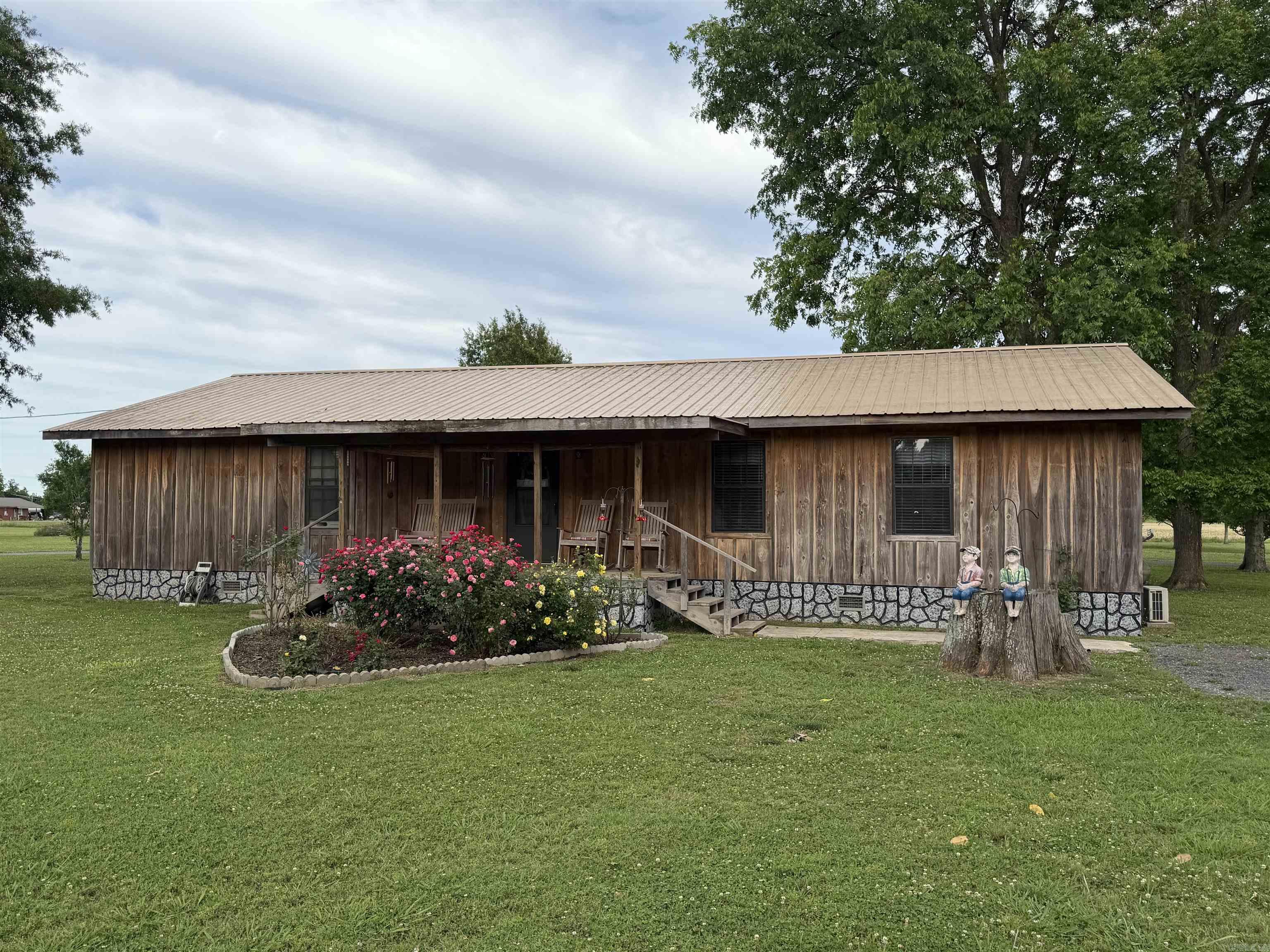 Situated on 3.6 acres, this unique property offers space, flexibility, and endless possibilities. Originally a 16x60 single-wide mobile home, it has been expanded into a spacious home featuring 4 bedrooms, 3.5 bathrooms, and approximately 2,112 heated square feet. The home also includes a separate dining room, large walk-in closet, and a walk-in safe room built within the home. Additional features include a gas ventless log fireplace, gas emergency heat unit, 25x24 carport, 22x12 screened-in porch, and a wood storage building. A standout feature of the property is the 40x50 metal shop with a 20x50 enclosed area and a 20x50 overhang. The enclosed portion is finished with beautiful cypress lumber on the interior and offers potential for additional living space, guest quarters, or even a separate home. The rustic finish can be enjoyed as is or customized with stain to match your personal style.
