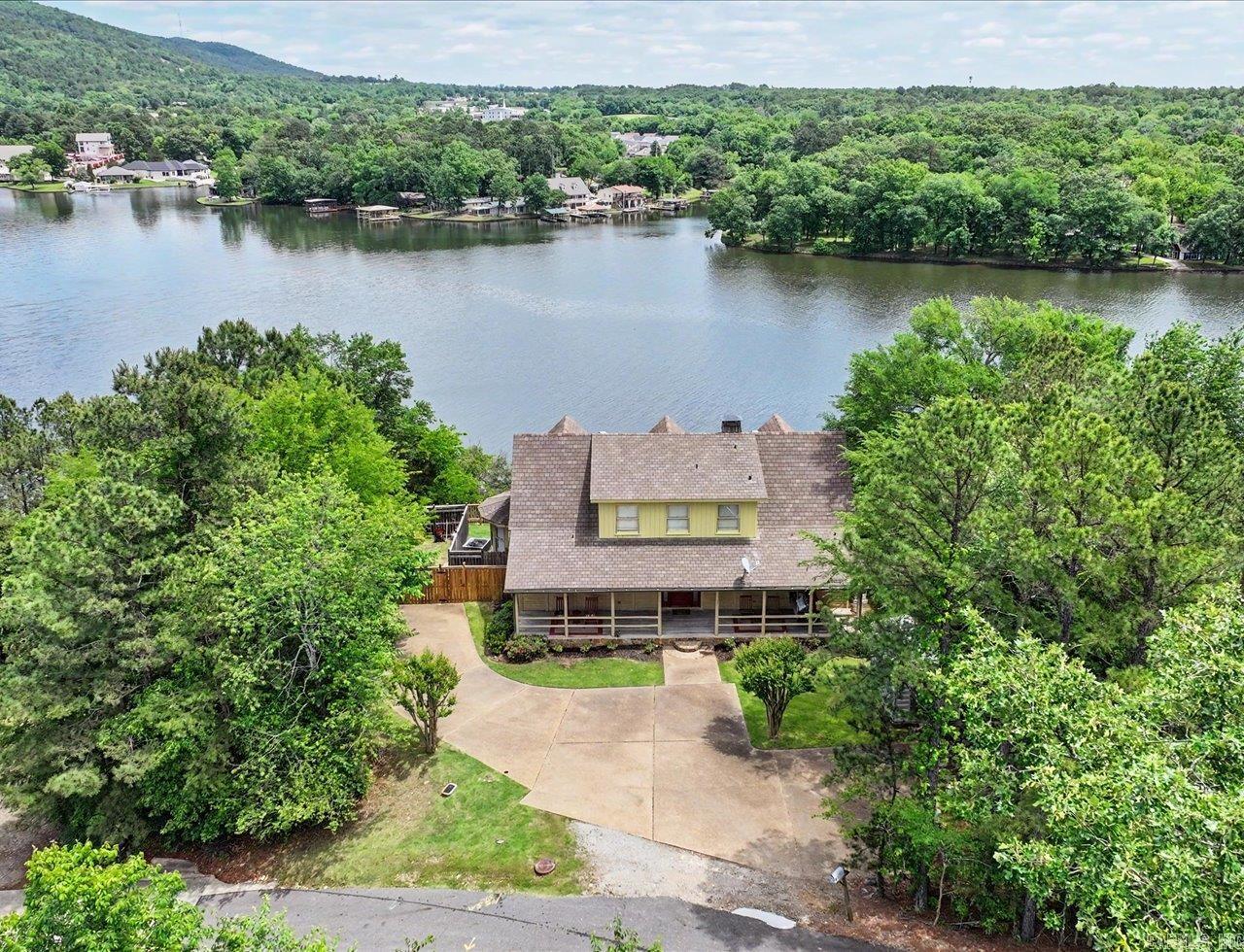 Experience breathtaking lakefront luxury log home living in this stunning 3-bed, 2 1/2-bath home spanning 2,172 sq ft in the sought-after Lake Ridge subdivision. Home off the beautiful Lake Hamilton spanning almost 8,000 surface acres invites you to enjoy fishing, recreational boating, swimming, skiing, jet skiing, and more. This luxurious haven features an airy, light filled floor plan. The great room has a wall of glass overlooking the lake with an awesome scenic mountainview in the distance. Upstairs is a balcony above the living room that provides another glamorous view of the sparkling lake. All 3 bedrooms provide a warm view of the lake with the 2 upstairs also having gabled ceilings. Long front porch, great for morning coffee as sun rises. Back deck great for grilling and gatherings (patio furniture and grill stays). The kitchen boasts stainless steal appliances to include a frig with lower french drawer freezer and gas stove for that chef inspired food prep taste. Two central air units add to the home’s efficiency. Cozy up to the woodburning (optional gas) fireplace during the chilly seasons. Don’t miss out on this luxury lake front home – schedule your private tour today!