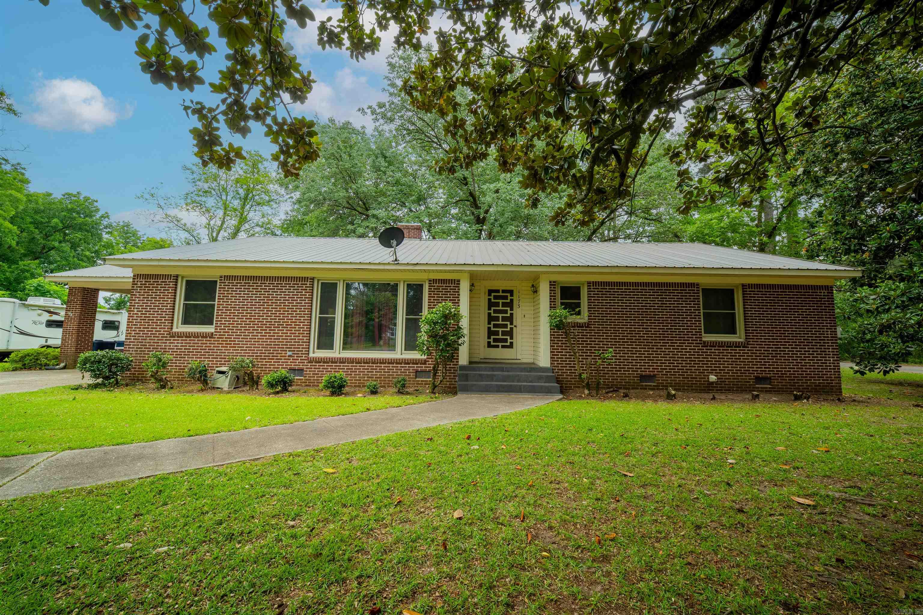 Welcome home to this solid brick 3-bedroom, 2-bath residence conveniently located near everyday amenities. Inside, you’ll find beautiful hardwood floors in the bedrooms, a spacious living room perfect for gathering with family and friends, and a large eat-in kitchen offering plenty of room for meals and entertaining. Step outside through the accessible French doors to a covered patio overlooking the fully fenced backyard—ideal for pets, children, and outdoor enjoyment. The home also features a large laundry room with abundant storage space, providing added functionality and convenience. Major updates include a roof replacement in 2020 and windows upgraded to vinyl. Completing the property is a attached covered carport and a 12x24 storage building, offering excellent space for additional storage. This well-maintained home is ready for its next owner to move in and make it their own!