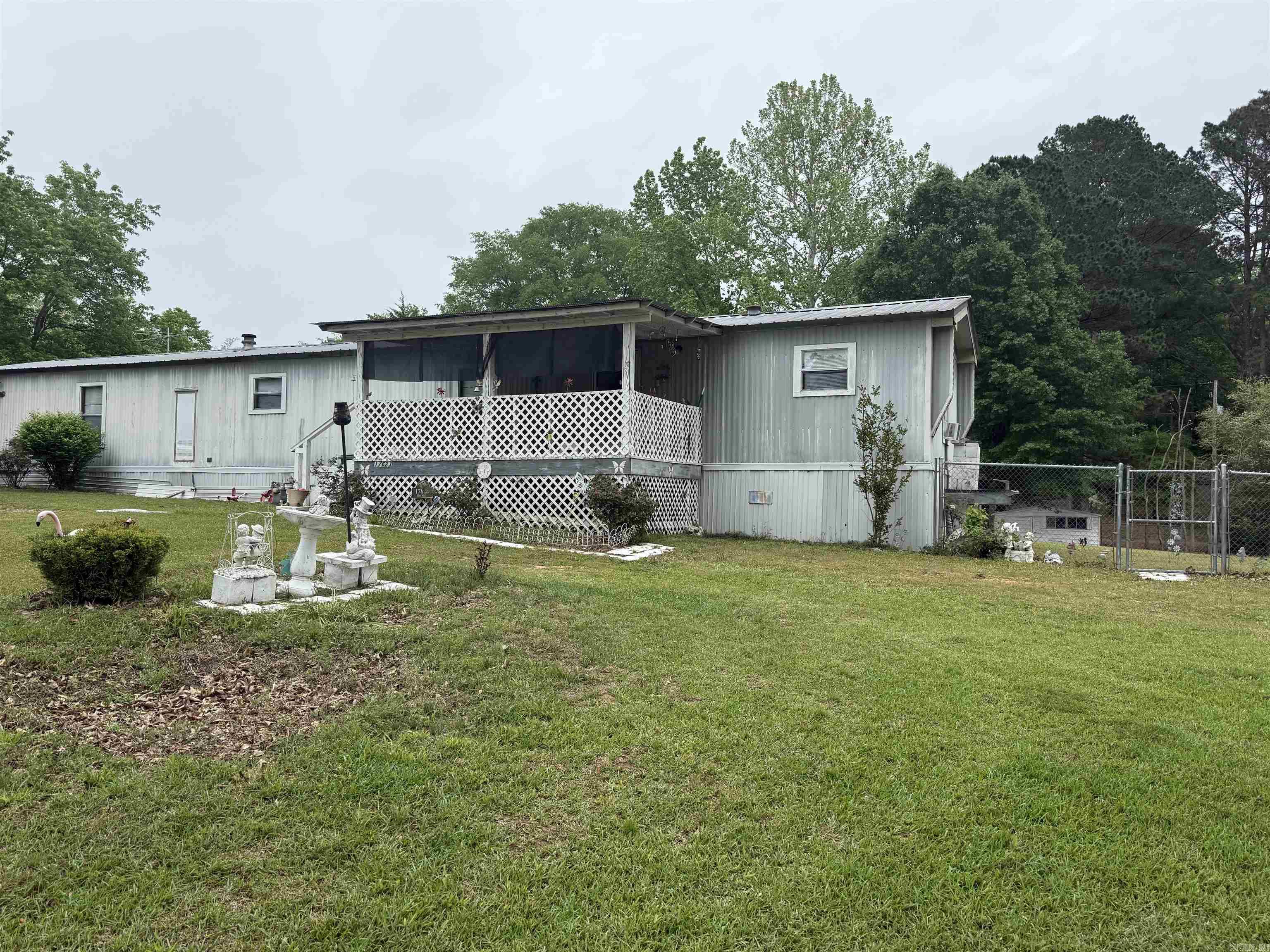 Affordable country living with room to grow! This 2-bedroom, 2-bath singlewide mobile home sits on approximately 0.94 acres in Pulaski County, just outside city limits—offering the peace of rural living with the convenience of nearby amenities. The home is livable as-is, making it a great option for those looking to move in right away while adding their own personal touches over time.  The property features a fully fenced yard, perfect for pets, gardening, or simply enjoying your own private space. A storm/safe room provides added security and peace of mind, while multiple storage buildings offer plenty of space for tools, equipment, or hobbies.  Located just a short drive from shopping, dining, and the surrounding areas of Little Rock, Shannon Hills, and Bryant, you’ll enjoy both accessibility and privacy. Properties like this—nearly an acre, livable, and priced under $100,000—are becoming increasingly rare.  If you’ve been searching for an affordable opportunity with potential, this is it. Opportunity awaits!