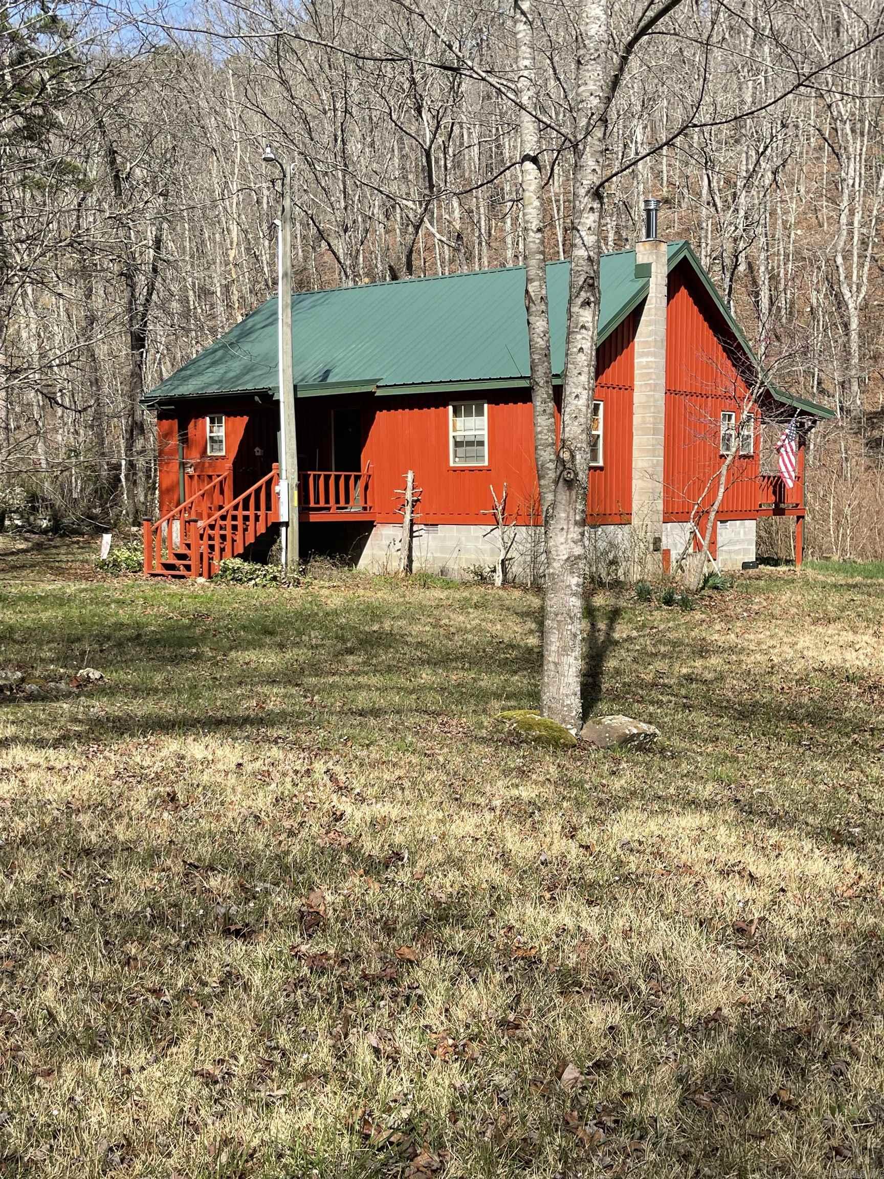 Mountain cabin.. hideaway.. cabin by the creek.. bug-out cabin..  "my happy place"..  There are so many ways to describe this unique property.  If you want to disappear from the world but still 30 minutes to a store then this is a wonderful opportunity to get off the beaten path.  Cabin has a year round creek just feet from the back porch  perfect for watching the deer, turkey, bear and other wildlife coming for a drink.  The bottom floor has a bedroom w/ bath and there's a second full bath for the common area and loft.  The wood burning stove has a brand new flue that employs Secondary Combustion Technology that recycles unburnt gases and re-burns them to make the store super efficient.  The kitchen window looks toward the creek while fixing a country breakfast to enjoy in the eat-in-kitchen area or on summer days enjoy the back porch.  Speaking of, the back porch runs the length of the cabin with ceiling fans to stir the cool valley air while you relax with a book or take an afternoon nap.  There is one cabin further down the drive and across the creek that the owners visit several times a month so someone is normally close by.  I want to "bug-out" just for fun.