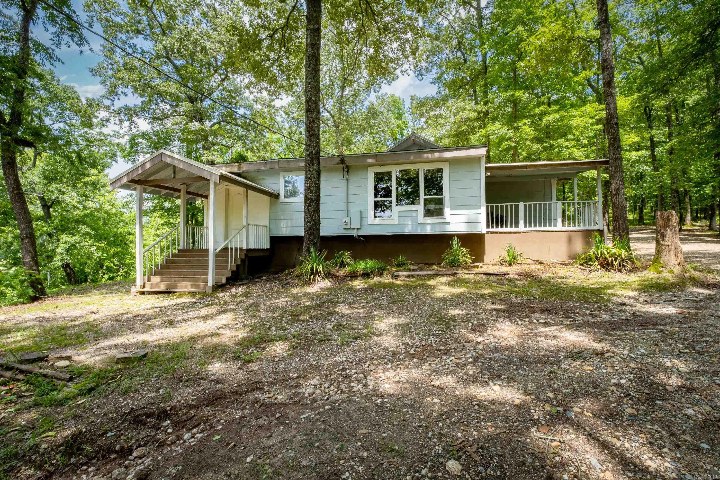 Come see this one-of-a-kind property, A national park-like setting near Little Rock Hot springs and Benton. With pristine "old-growth" trees overlooking a clear year-round creek that has swimming holes for the kids on hot summer days. This unique property has miles of trails featuring suspension bridges and footbridges that take you through old-growth pristine woodland.  The creek water filters through natural occurring quartz crystal gravel that has a bluish clearness and is a great soak and swim experience.   The custom 3 bed, 2 bath house is a serene escape which blends seamlessly with nature. This home's three comfortable bedrooms are perfect for restful nights surrounded by the quiet sounds of the forest and creek.  This woodland retreat surrounded by pristine nature is a true sanctuary for birds, wildlife and you.  It helps you forget life's ups and downs and let's you just soak up the beauty and tranquility of this part of the Natural State. See Agent Remarks