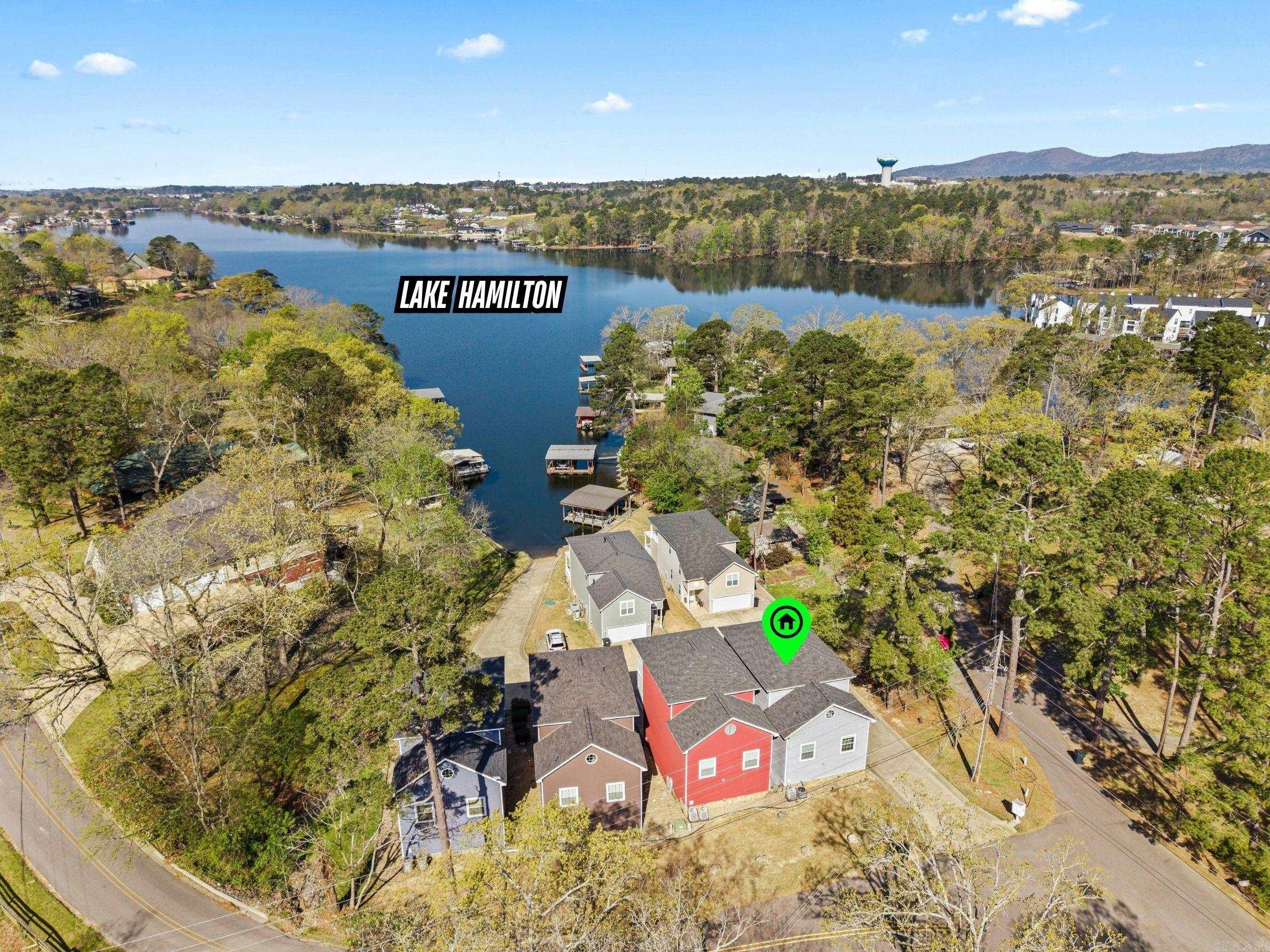 Unpack your bags and experience Lake Hamilton living in this rare 3BR/2BA home! Located in an exclusive enclave of just 6 homes, this fully furnished retreat offers the ultimate low-maintenance lifestyle. The HOA covers exterior yard care, and upkeep of the community boardwalk—complete with water tie-offs for your boat and a private boat ramp. Inside, enjoy an airy open-concept layout boasting designer finishes: luxury vinyl plank flooring, stunning quartz countertops, and spa-like bathrooms. Step outside to two large decks perfect for entertaining and soaking in the lake views. A massive oversized garage easily accommodates your boat trailer and water toys! This would make a wonderful low stress vacation home or your home base Lakehouse!  All furniture is included in the sale. Mechanical Peace of Mind: New roof (2023) and a high-efficiency HVAC system (2022) deck fully replaced and stained with IR Reflective stain (2025) Located within a short drive to historic downtown, Oaklawn racing, shopping and restaurants this home represents a rare lifestyle upgrade. Come enjoy all Hot Springs has to offer. Agents see remarks.