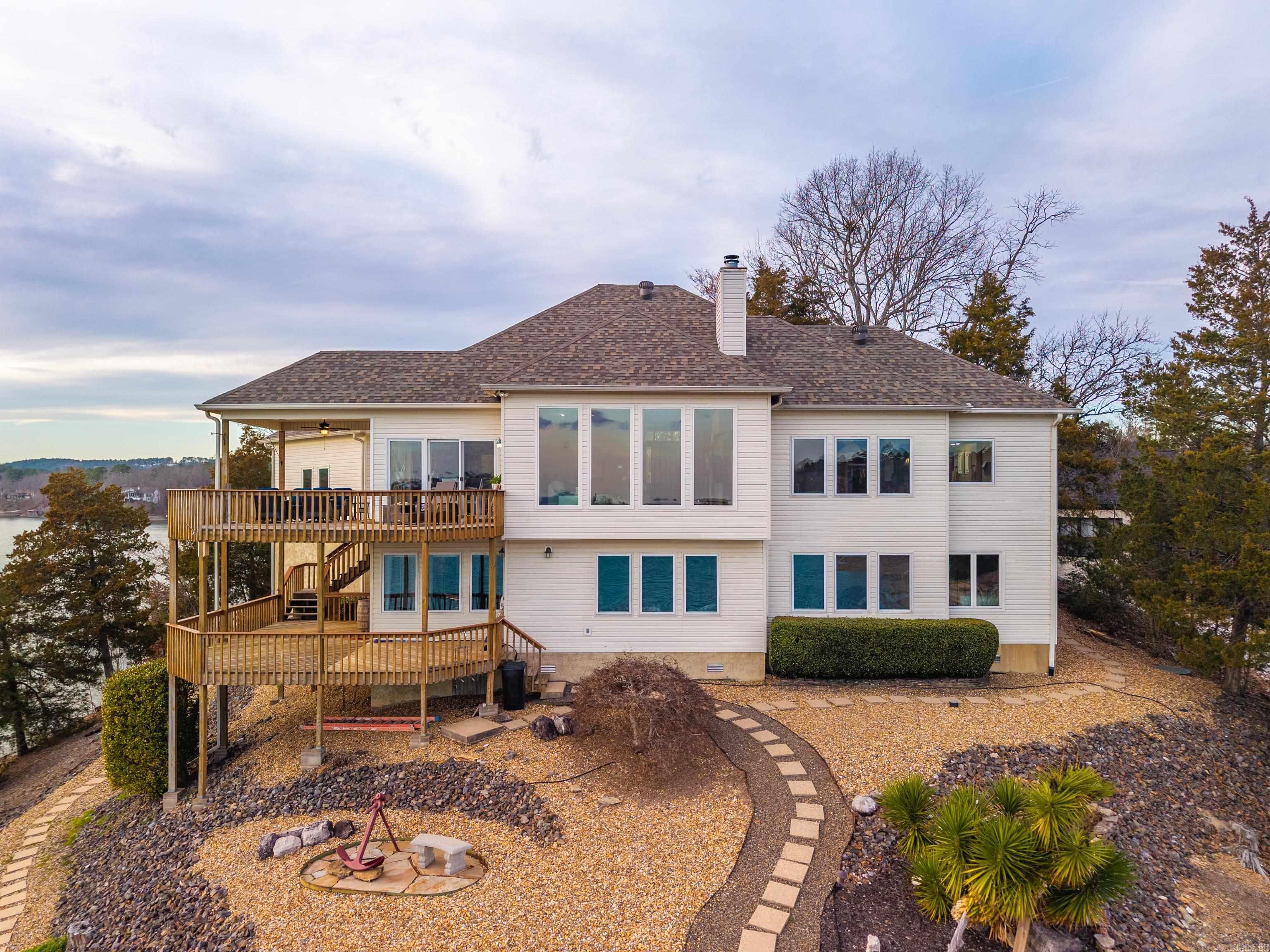 Nestled on the shores of Hot Springs Village and overlooking beautiful Lake Balboa, this 5-bedroom, 4.5-bath lakefront home offers breathtaking panoramic water views from two expansive decks designed for exceptional lake living. Don’t let the seasonal draw-down distract from the true beauty of this exceptional point property. Positioned in one of the most desirable locations on the lake, this home offers breathtaking views year-round—including front-row seats to the Lake Balboa fireworks right from the deck. Located in Hot Springs Village, owners enjoy access to premier amenities including golf, tennis, pickleball, hiking trails, and more. The main level features the primary bedroom and bath, living room with vaulted ceilings and new windows to maximize the incredible lake views, along with the kitchen and laundry for convenient one-level living. The lower level is ideal for entertaining and guest accommodations, offering additional bedrooms and baths, a sauna, game room, and media room. Additional highlights include a covered deck, private covered boat dock, and a roof with an extended warranty—providing peace of mind while delivering the ultimate Lake Balboa lifestyle experience.