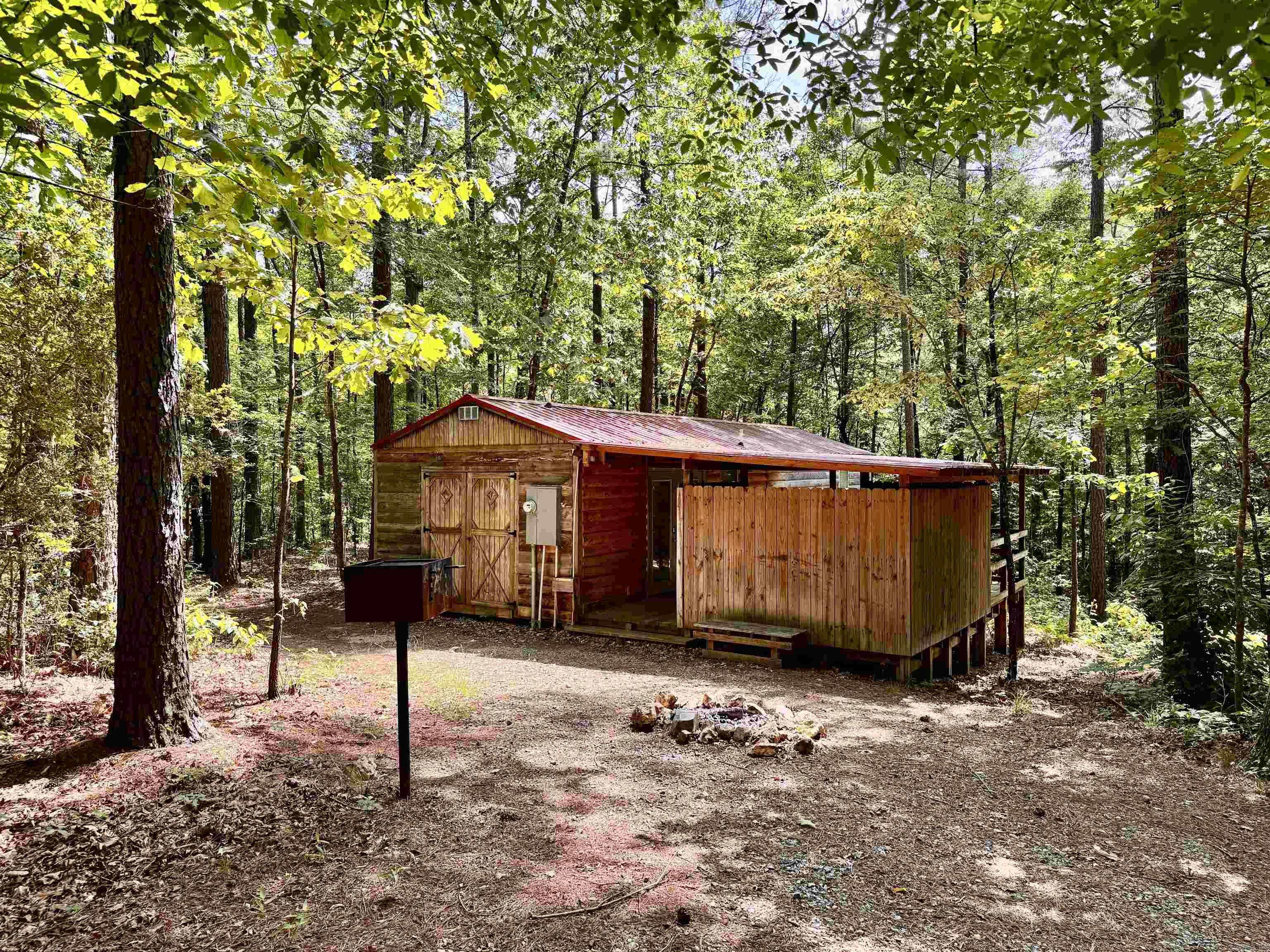 So many opportunities with this tiny home cabin in a beautiful natural setting. The 540 sq ft 1-bed 1-bath tiny home has been built to high-quality standards. This unit has been used as short-term rentals and has a wonderful rental history.  It is being separated from Knotty & Nice cabin rentals, which all used one water source. A well will need to be installed. Seller will allow water to be used from their well for 30 days after closing to allow time to have this done. The cabin has its own septic system. Enjoy the outdoor hot tub. Taxes will need to be figured separately from the entire complex, so the listing is not accurate there. Acreage will be adjusted on listing once the survey is completed.
