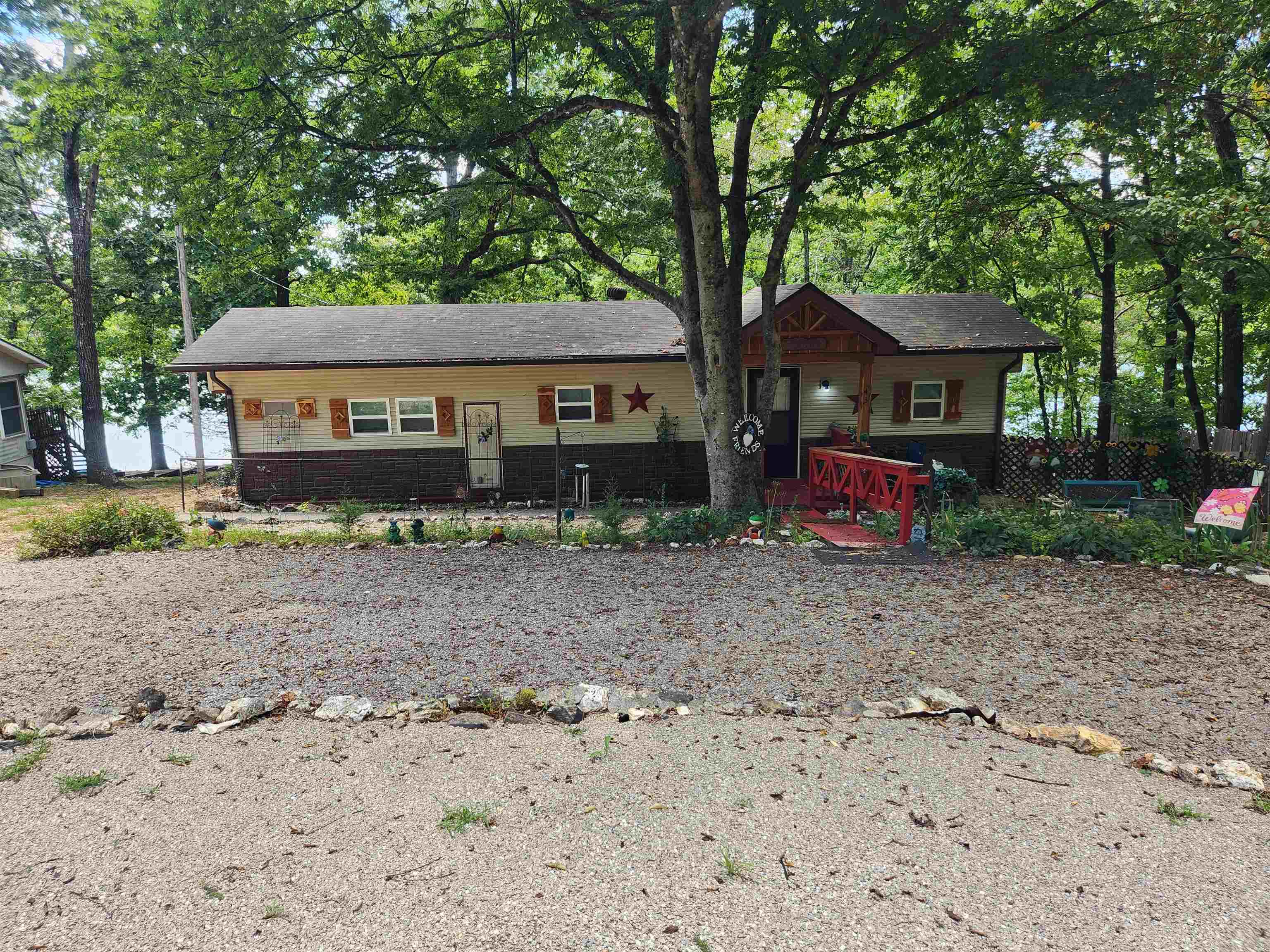 Lakefront home in Highland Arkansas. Come fish or swim in Beautiful Lake Mirandy. Or just sit on your back deck and watch the sunsets over the lake. This completely remodeled home can be your weekend getaway, your vacation place or it could be your permanent/retirement home on a lake. This home has got to be seen to be appreciated. From the full-length back porch to the brand-new vinyl siding. Updates like new flooring, new stainless-steel appliances, a ginormous jacuzzi tub and a shower in the updated primary bathroom. The guest bedroom room has its own private half-bath. Lake views from every room. There is a deck with a pergola down near the lake and a fishing/swimming dock w/storage on the lake. There is also a 10 x 12 outbuilding for storage, lake toys, and or lawn equipment. This lakefront property has been updated inside and out with landscaping, covered porches and all new doors and windows. Wonderful craftsmanship throughout the home.