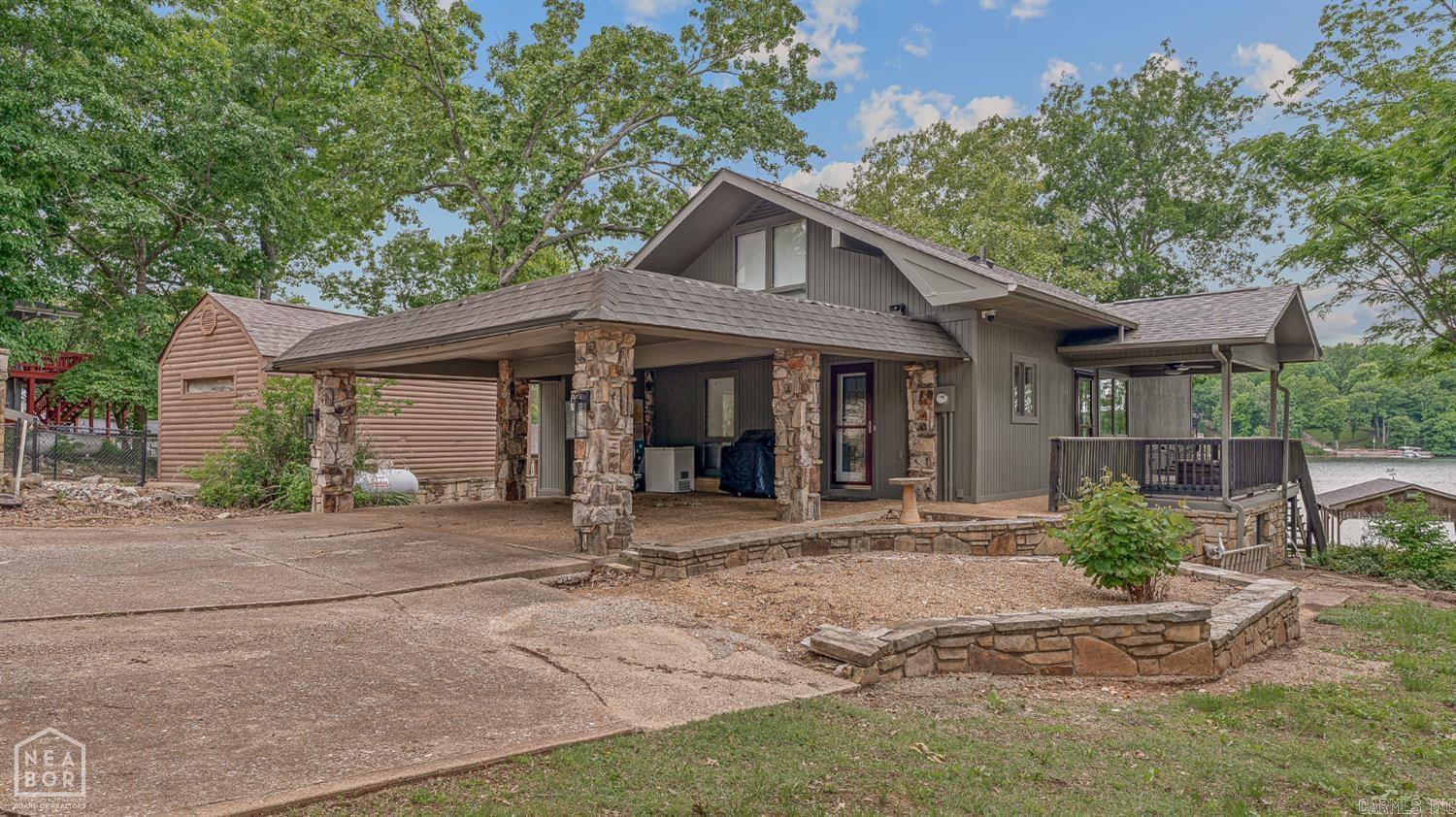 Lake house living in one of the best locations on beautiful no wake Lake Seqouyah which connects through canal the to Lake Thunderbird! This home truly offers it all. Situated on a point lot with approximately 1.5 lots, the property provides exceptional water access and views. The exterior amenities include a private sand beach, covered boat storage, two docks accommodating up to five boats, a large fire pit, RV parking pad with electric, septic, and water hookups, a storage building for lake toys, and more. Inside, the home features panoramic lake views and an open floor plan that is ideal for entertaining. The main level includes the kitchen, breakfast area, dining area, one bedroom, storage closets, and a full bathroom. The kitchen offers a stainless steel stove and microwave, along with a breakfast bar for easy serving. The living room showcases faux wood beams and a large stone fireplace. Just off the main living area is a wraparound deck, perfect for grilling and relaxing, with a covered seating area. Upstairs, you'll find two spacious bedrooms that can accommodate multiple beds for guests, along with a full bathroom. This is a must see property! Schedule a showing today!