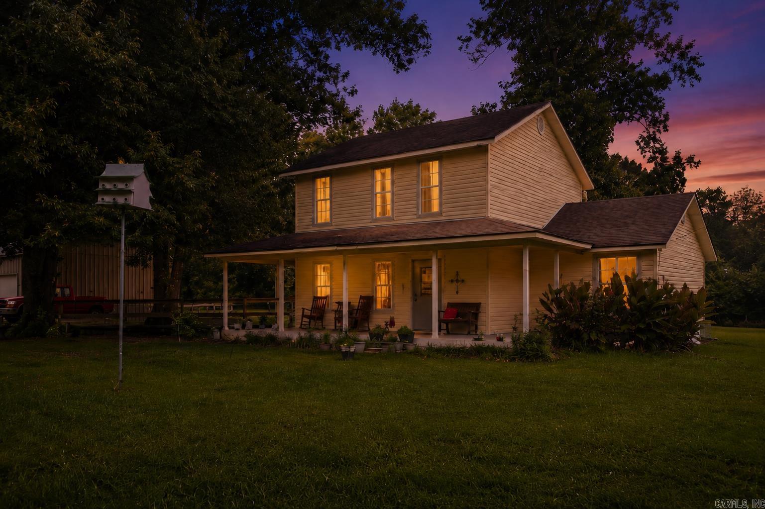 4875 Highway 375 West, Mena | Four solid acres of mature hardwoods, open pasture, and the kind of quiet that makes you check your pulse. This 1,500 sq. ft., two-story 2003 home keeps the primary suite on the main floor, because climbing stairs just to go to sleep is like having a screen door on a submarine. With 3 beds and 2 baths, it boasts a traditional floor plan. Kitchen, dining, and living rooms all do their own jobs instead of bleeding together into an open-concept chaos. Outside, you’ll find a massive carport ready for your RV, boat, or bad financial decisions. There's also a big detached shop for "projects" you’ll definitely finish someday, plus a fenced yard ready for dogs, chickens, or the livestock hobby you swear isn't taking over your life. Level ground, shade trees, and zero audience. You’re close enough to town for toilet paper, but far enough to pretend you’re off the grid on purpose. Plenty of deer hanging around too, whether you want to admire them or put them in the freezer. So stop creeping on real estate listings at midnight and let's go look at this home!