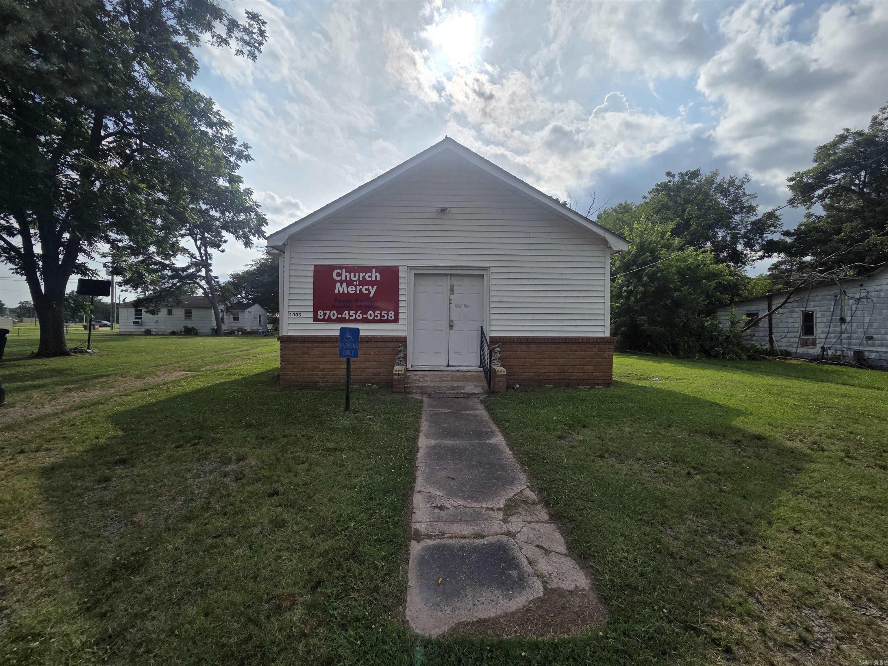Rare opportunity in an Arkansas Economic Opportunity Zone! Former church property offering strong potential for redevelopment, investment, or continued community use. Currently zoned R2. Located in a tax-advantaged incentive area, this property is ideal for investors seeking value-add opportunities.  Main structure includes a spacious sanctuary with existing pew seating, two front-entry restrooms, small office area, and central heat and air. Rear section features flexible living quarters configured with a large living/dining area, kitchen, full bathroom, and three bedrooms (formerly Sunday school rooms).  Property offers multiple possibilities including church use, event or community space, rental conversion, or full redevelopment. Sold AS-IS and priced accordingly for needed updates and repairs.  Situated on approximately 0.33 acres with irregular lot (see survey for exact boundaries). Year built is unknown. Buyer to verify zoning, square footage, and intended use.
