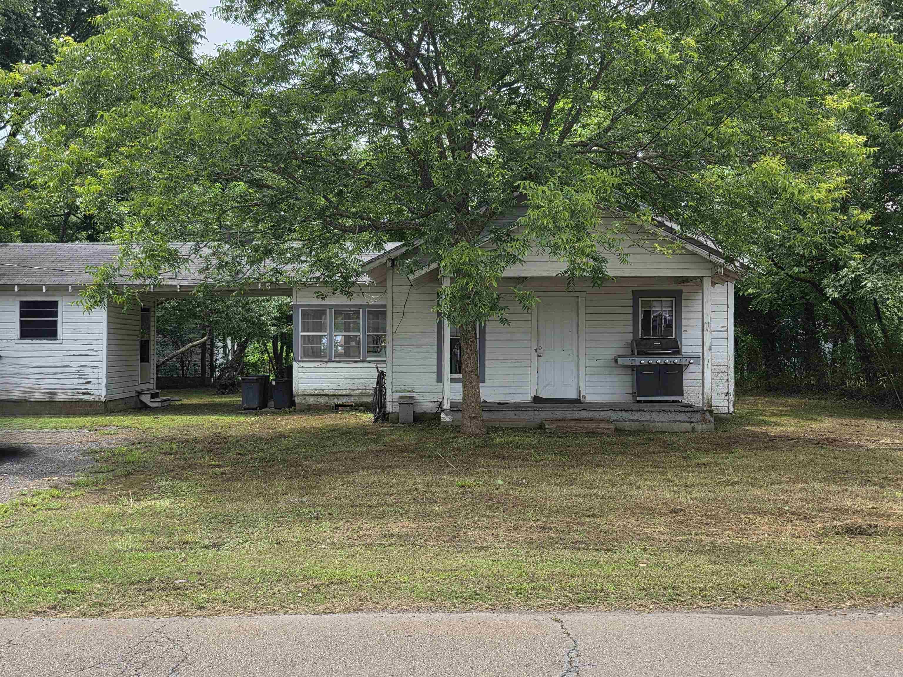 Perfect investment opportunity in the heart of Mena! It's just a hop away from the new bike trails, offering lots of space for your creative ideas. This cozy two-bedroom, one-bath home comes with a delightful screened-in porch and a welcoming covered front porch, making it perfect for relaxing. You'll also find a charming fire pit, a handy storage shed, and a convenient carport. The kitchen and dining area have lovely built-in features, too! At this price, you can easily turn this property into an adorable little bungalow. Come see the potential! Agents see remarks before showing