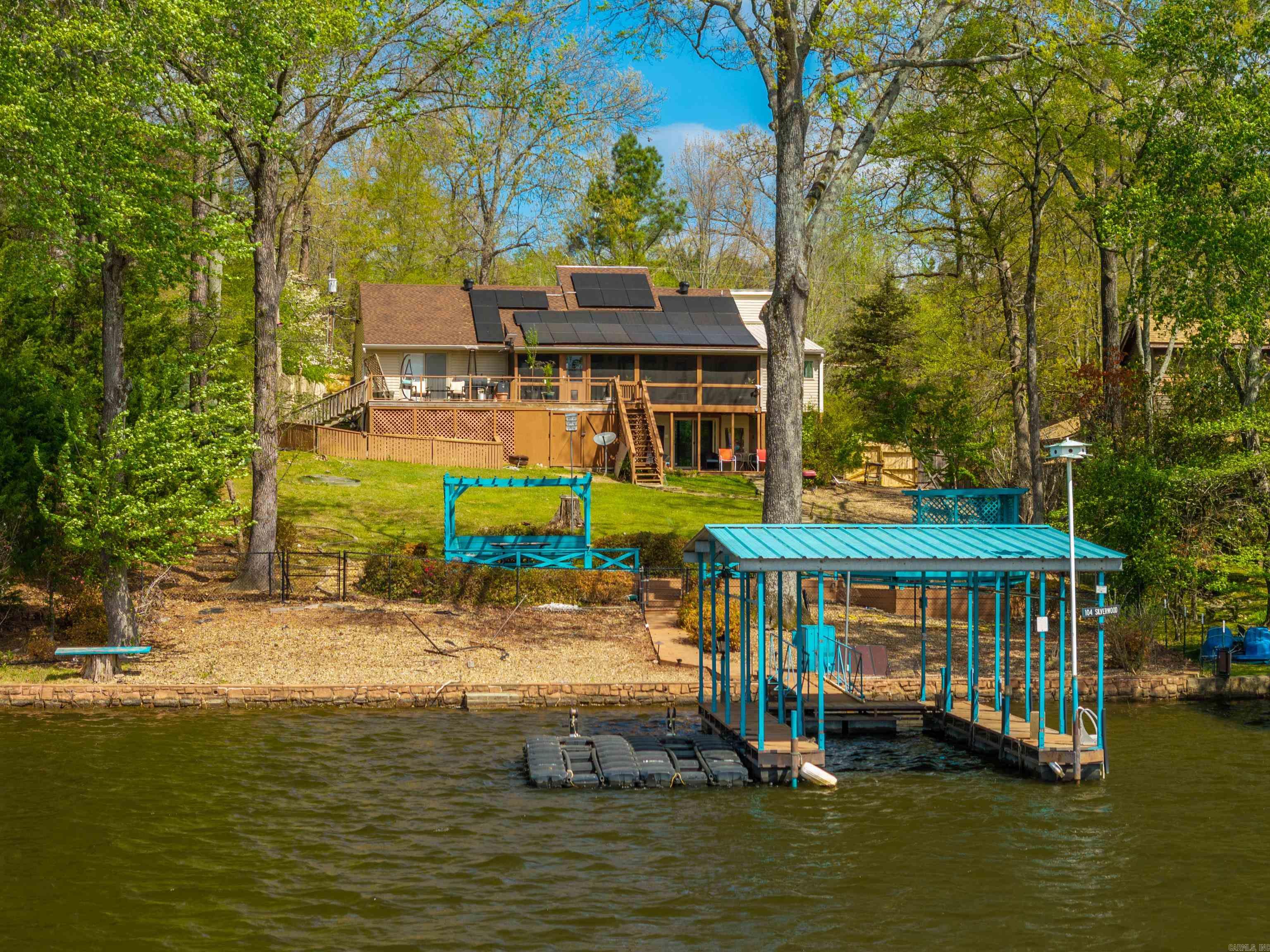 *Motivated Seller*Imagine the ultimate blend of lakefront luxury, energy efficiency, and passive income potential, all wrapped into one incredible property. Situated directly on Lake Hamilton and fed by the Mazarn, this 2,700 sq. ft. has been updated. The home offers peace of mind with a brand-new roof and fully paid-off solar panels. Inside, the main level is designed features a wood burning fireplace, featuring two spacious bedrooms, 2 full baths, an office, a den, and showstopping kitchen anchored by a massive quartzite island and professional-grade smart appliances. Added conveniences like a dedicated ice maker. The property’s versatility is truly unmatched thanks to the lower-level private suite. Currently operating as a VRBO, this space features its own kitchen, full bath, & separate locked entrance, making it the perfect setup for rental income, multigenerational living, or a guest retreat. Beyond the interior, the lifestyle continues at the water's edge with an expansive patio, fully fenced, covered floating boat dock, and two jet ski ramps. For reliability, the home features a whole-home generator. Spray foam insulation. No restrictions. Selling AS-IS
