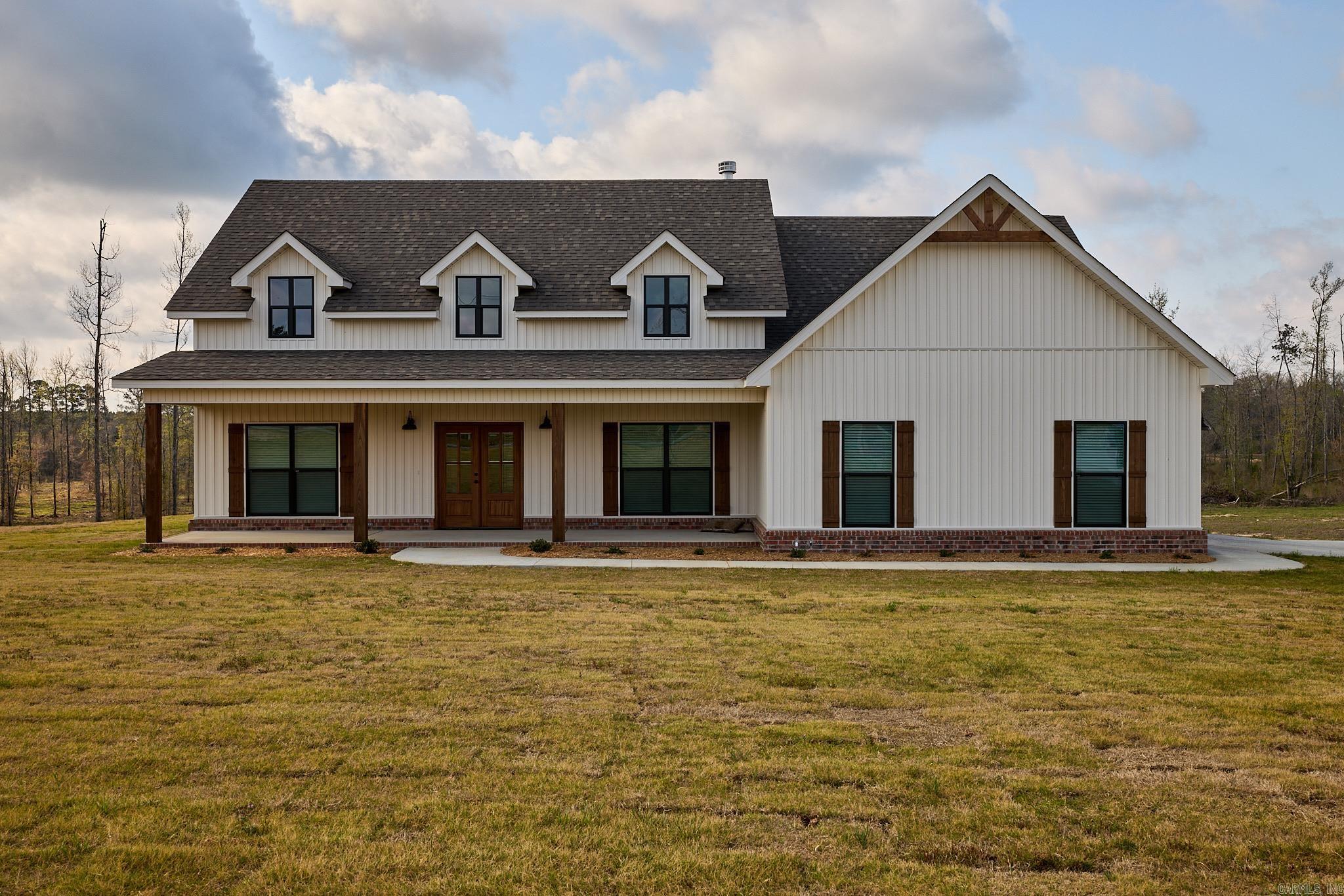 New construction in a growing area of Bauxite featuring 3 bedrooms, 2 bathrooms, and 2,217 sq ft. You’re greeted by a large front porch with double front doors and a side-load garage. This open-concept home offers a vaulted, beamed living room ceiling with a woodburning fireplace, hardwood floors in the main living area, carpeted bedrooms, and tile in wet areas. The kitchen includes quartz countertops and a walk-in pantry. Just off the foyer is a versatile office or dining room with a closet. The primary suite features a soaking tub, walk-in shower, double vanity, and private water closet. Additional highlights include a mudroom, a separate laundry room with a sink and folding area. This property has a spacious backyard plus a 20x20 shop that will be added to the property—giving you extra space for storage, hobbies, or workspace.