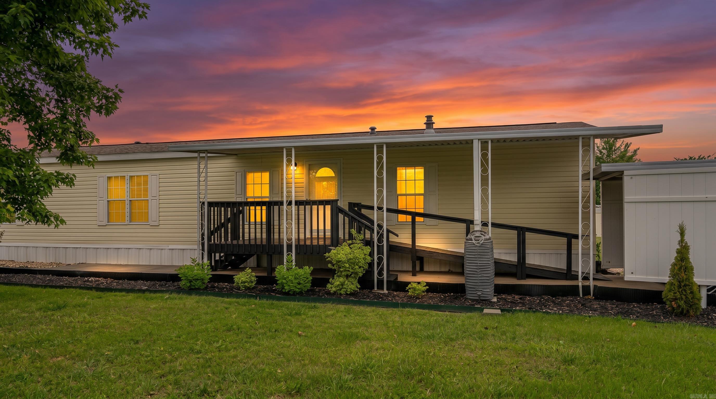 Located in the heart of the Arkansas Ozarks near the Missouri state line, this well-maintained 2011 single-wide home offers comfortable, low-maintenance living in a peaceful 55+ community in Mountain Home, Arkansas. Near Bull Shoals Lake, Lake Norfork, and the Buffalo National River, the property is perfect for enjoying fishing, boating, and outdoor recreation.  The 16x80 home features sheetrock walls and ceilings, giving it a more residential feel throughout the spacious 2-bedroom, 2-bath layout. The kitchen includes granite countertops and a decorative rock accent wall, while the primary suite offers a private bath with a garden soaking tub. Central heat and air provide year-round comfort, and updates include newer windows and a roof replaced approximately two years ago.  Outside features include a covered front deck, back deck, handicap-accessible design, attached 2-car carport, concrete parking pad, and a 10x15 storage shed. Residents also enjoy access to a stocked community lake. Property is subject to a monthly lot fee.  CAN BE SOLD FURNISHED