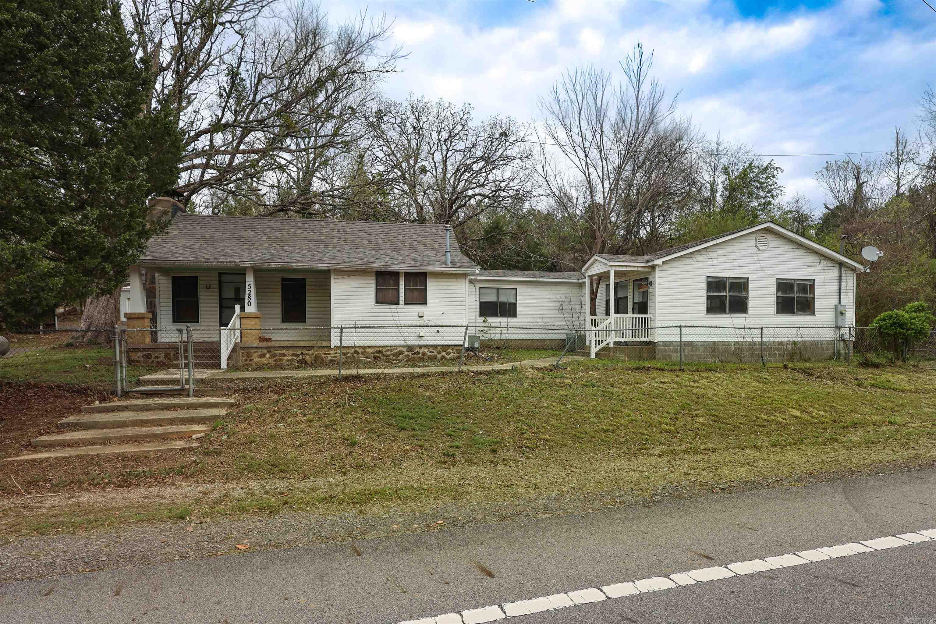Located in a highly sought-after lake area, this property offers great potential just 2 miles from Mountain Harbor and 25 miles from Hot Springs. The home features 3 bedrooms, 2 bathrooms, and over 3,400 square feet under roof, including 3,114 heated and cooled. With solid structure and spacious layout, it’s ready for your updates. A new roof installed in 2026 adds added value.  The property includes a 26x56 shop with three roll-up doors and asphalt floor, 12x20 barn with lean-to, 12x20 multi-purpose building, 8x10 storage building, and 7x8 pole shed. Asphalt driveway in place. Ideal for full-time living, a lake-area getaway, or a property with ample workspace and storage near Lake Ouachita.