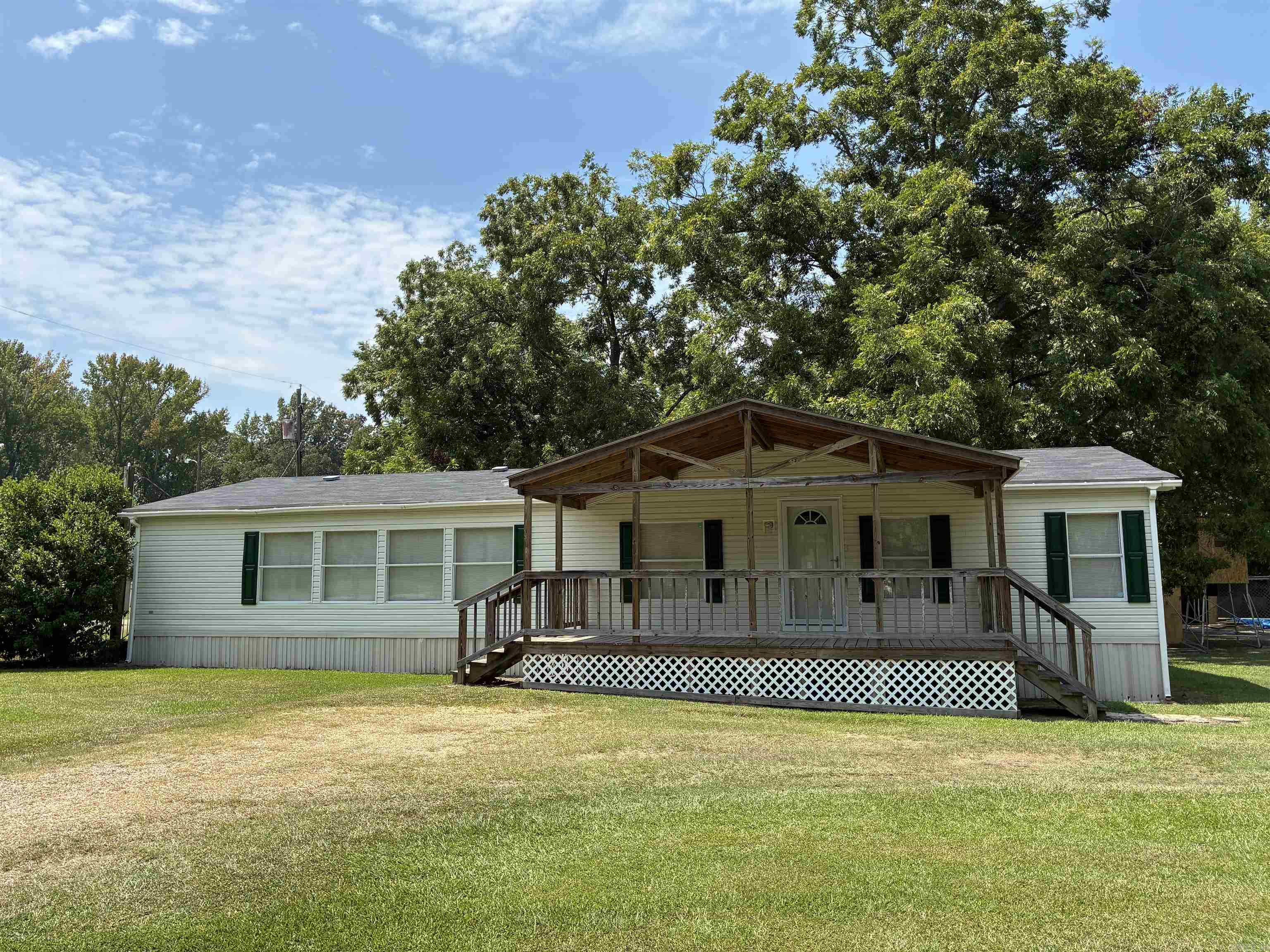 2005 1,680 sqft mobile home permanently affixed to a 0.38-acre corner lot. Immaculate condition. 3 bedroom / 2 bath, all electric. 2017 updates include paint and flooring throughout and remodeled primary bathroom. Large laundry room with side entrance. Beautiful 10x22 covered front porch. 2025 front storm door. Roof with gutters installed 2021. Original HVAC. Concrete slab patio. Title has been surrendered to the state. Mobile home permanently attached to real property.