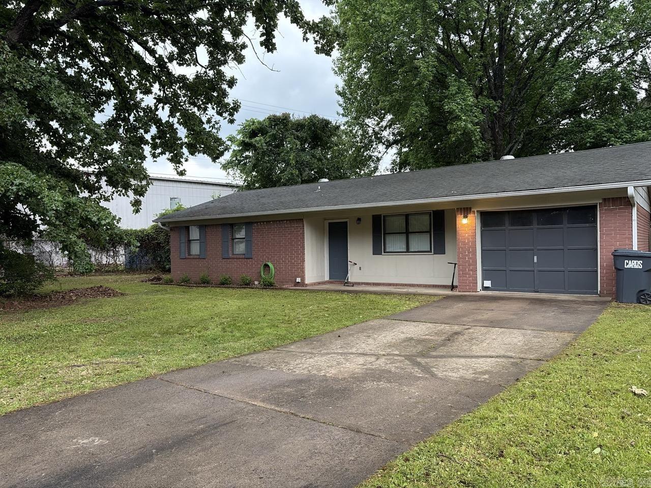 Welcome to 2112 E 14th St, a charming and meticulously maintained brick ranch nestled on a quiet, established lot in the heart of Russellville. This inviting residence offers 1,120 square feet of living space that seamlessly blends classic durability with modern updates. Step inside to find a bright, open-concept floor plan highlighted by fresh neutral paint and a mix of stylish new flooring and plush carpeting. While currently configured as a spacious two-bedroom, the home’s generous layout provides the unique flexibility to easily convert a portion of the living area into a third bedroom or a dedicated home office to suit your specific needs.  The exterior of the property is just as impressive, featuring a fully fenced backyard that serves as a private oasis for gardening, play, or outdoor entertaining. The classic brick facade ensures low-maintenance curb appeal, complemented by a tidy concrete driveway and an attached one-car garage. For those who need extra space for hobbies or seasonal storage, the property includes a sturdy storage building in the rear. Located within the Russellville School District and just minutes from the high school, local shopping, and dining.