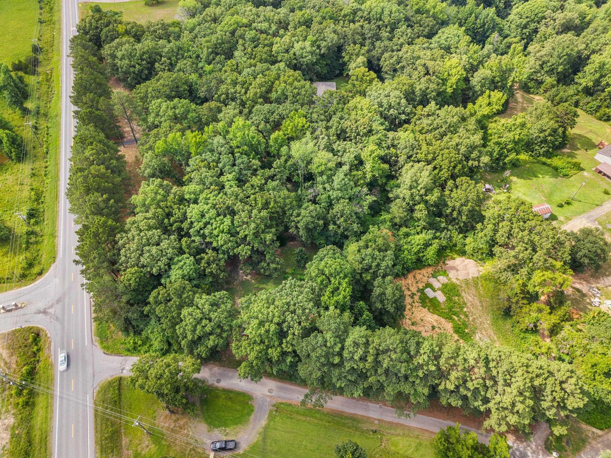 Discover the potential of this expansive property located at 0000 AR Hwy 5 in the thriving community of Cabot, Arkansas. This versatile lot offers a unique blend of residential and commercial opportunities, making it an ideal canvas for your dream project. Situated on Hwy 5, the property boasts excellent visibility and accessibility, perfect for future business ventures. Equipped with on-site power, two meters, and a waterline, it sets the stage for seamless development. The existing septic system, last used 10 years ago, provides a foundation for future utility needs. Additionally, the property includes a workshop and trailer shed, offering immediate utility for storage or project space. Outdoor gatherings can be enjoyed with a built-in smoke pit, adding rustic charm to the wooded landscape. The wooded terrain offers privacy and a natural backdrop, ideal for building a custom home or retreat. This property presents a remarkable opportunity to craft a space that suits both residential and commercial aspirations. Whether envisioning a new home nestled in nature or a business with prime highway exposure, this lot holds endless potential.