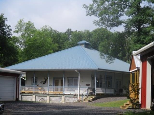 1,607 sq ft, 3-bedroom, 2-bath, open kitchen/living area, wrap-around porch. 2-car carport. Year round creek  30’x50' insulated metal building with slab floor and two 10' roll-up doors, loft for extra storage. 2-post 8,000 lb lift. 24’x36' insulated 3-car garage, slab floor with two roll-up doors. 22’x40' pole building, 12’x32' unfinished storage building. 12’x20' garden shed, 8’x12' well house