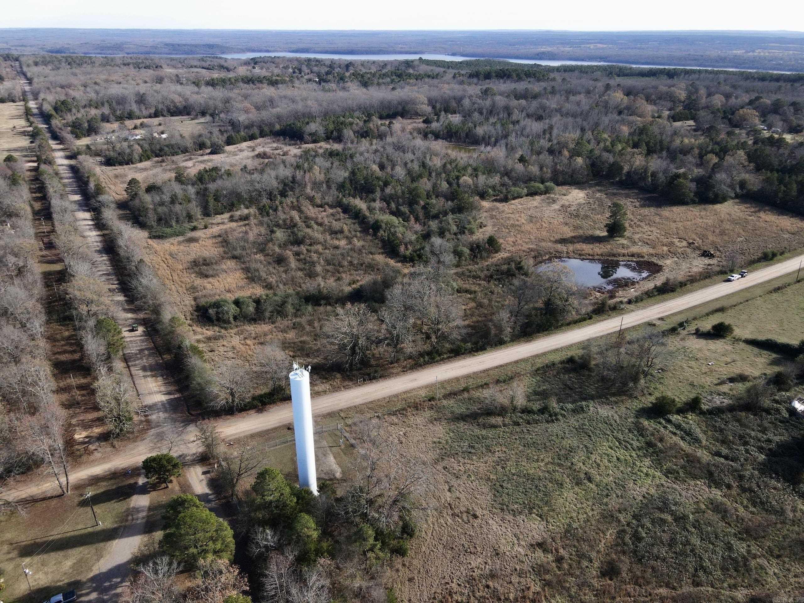 Discover a rare opportunity to own a versatile piece of rural land with endless potential - perfect for a hobby farm, hunting property, investment opportunity, or your own private country estate. This beautiful tract features gently rolling terrain and is bordered on two sides by county roads, offering excellent access and visibility. Utilities are already in place, including electricity and rural water, along the road, making it easy to start building or developing right away. The property features a well-balanced mix of open pasture and mature timber, making it ideal for livestock grazing, recreational use, or future development. Two ponds provide reliable water sources for cattle and wildlife, creating a natural draw for deer, turkey, and small game, making this an excellent hunting property. The land is fully fenced, with some cross-fencing already established, providing it with immediate functionality for grazing or livestock management. Multiple access points enhance the usability of the land, whether you're planning a homesite, weekend retreat, or long-term investment.