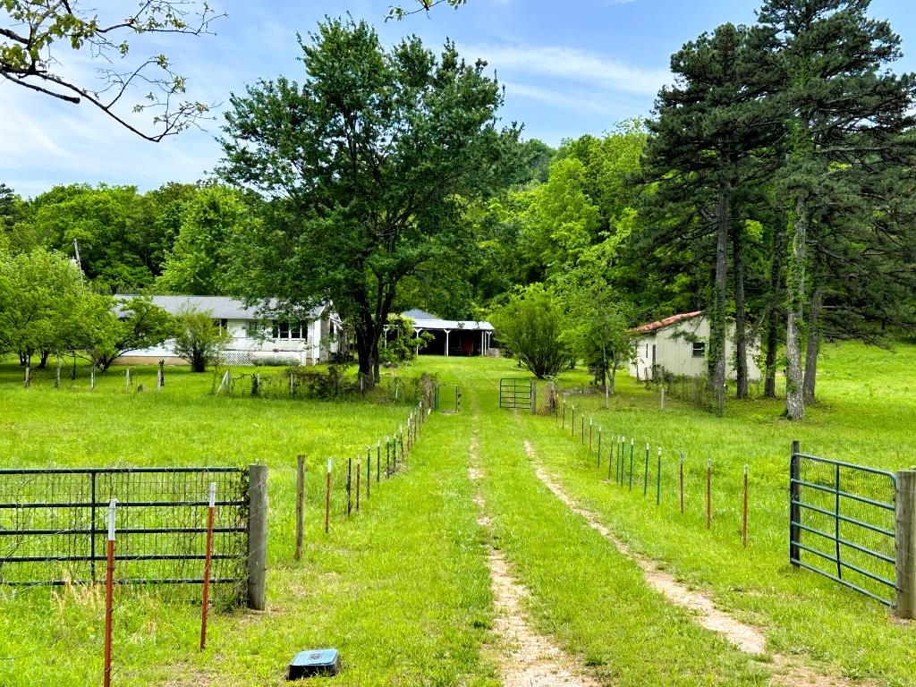 Country living with room to grow on 5.60 acres! This 1,344 sq ft home offers a great opportunity to own usable land with no restrictions and plenty of potential. The property is mostly pasture, fully fenced, and includes a small pond (ready for a little TLC), along with established fruit trees for a true homestead feel. Outbuildings are already in place with a 20x30 shop, a barn featuring large overhangs on two sides for equipment or livestock shelter, and a one-car carport. City water is connected, and the home also includes a Generac generator for added peace of mind. With county road frontage, access is easy and convenient. Inside, the home features central air and propane ventless heat. It could use new floor coverings and a fresh coat of paint—making it a great chance to add your personal touch and build equity. Whether you're looking for a small farm, weekend retreat, or investment property, this unrestricted acreage offers flexibility and value. Priced at $180,000 — don’t miss this affordable slice of the countryside!