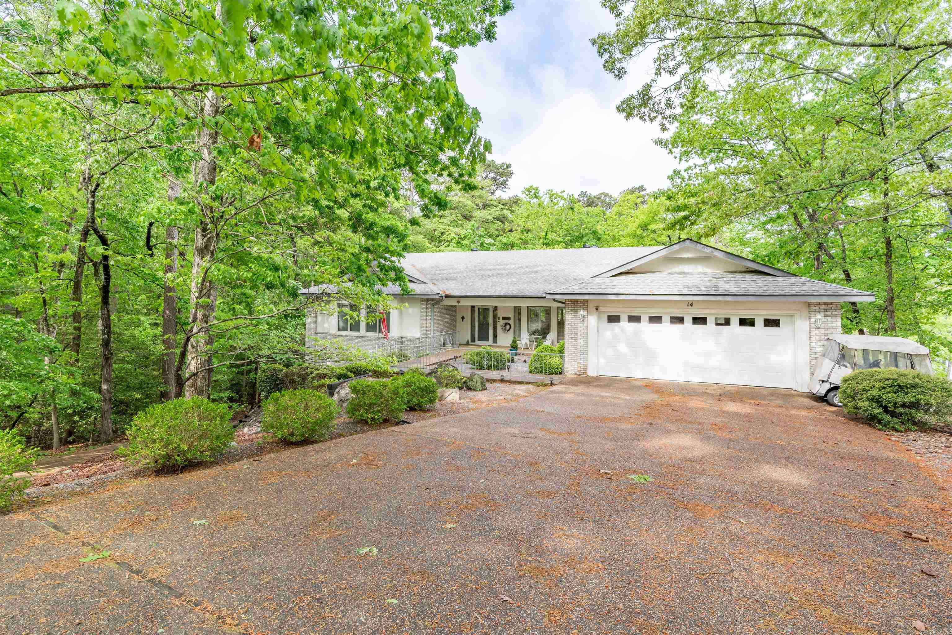 Enjoy lakefront living on beautiful Lake Balboa in this well-maintained Cooper Home; 3 bed, 2 bath home offering approximately 2,500 sq ft. Located just 2 minutes from the Balboa Gate for easy access in and out of Hot Springs Village and only 5 minutes from three golf courses, the setting combines convenience with a true lake lifestyle.  Inside, the home offers a comfortable, flowing layout between bedrooms, a separate dining area, and multiple living spaces that give flexibility for everyday living or hosting. Large windows bring in natural light and a double-sided gas fireplace creates a warm focal point shared between living spaces. The kitchen features a large breakfast bar for casual dining.  Out back, enjoy elevated views of Lake Balboa from the deck, with easy access down to your private dock complete with covered slip and lift— already equipped with a pontoon boat and golf cart making it easy to start enjoying both lake and Village right away. A heated/cooled workshop space and two-car garage add to the functionality of this home.  A great opportunity to own a lakefront property that offers both everyday comfort and the full Hot Springs Village. SEE AGENT REMARKS.